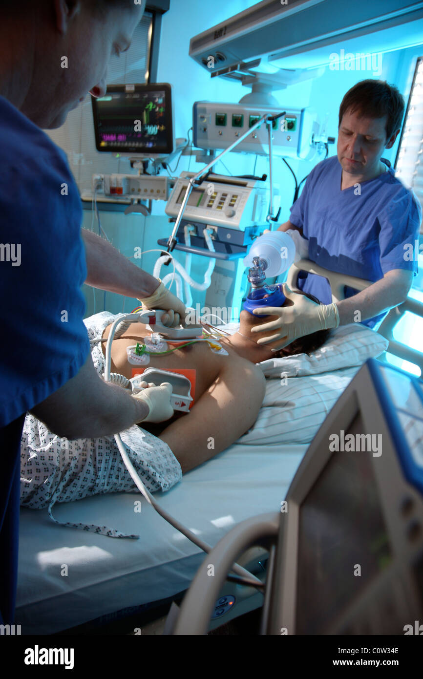 Unidad de cuidados intensivos de un hospital. Un paciente se conecta a diferentes sistemas de soporte de vida. Foto de stock