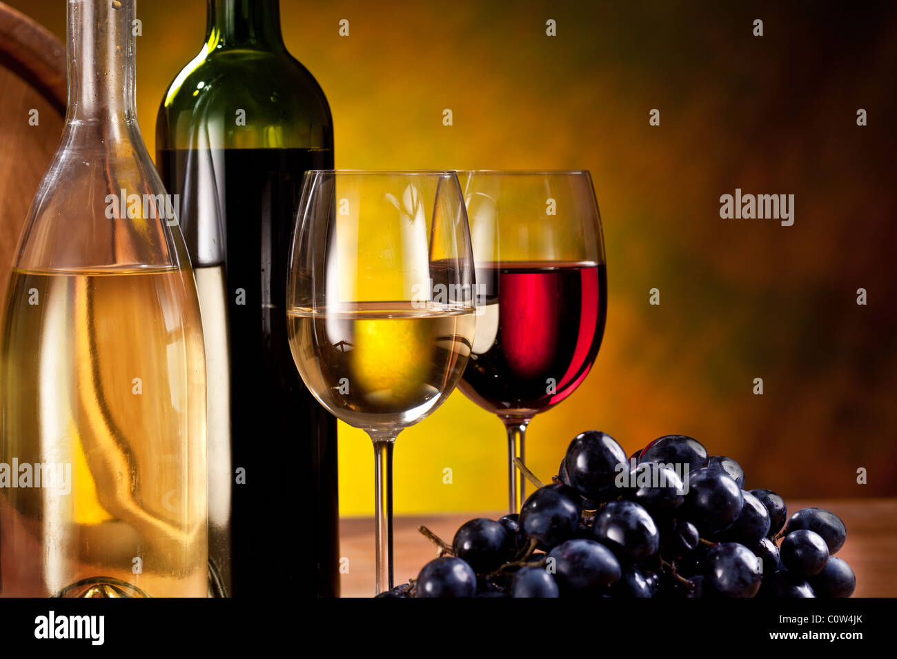 Bodegón con botellas de vino, vasos y barricas de roble. Foto de stock
