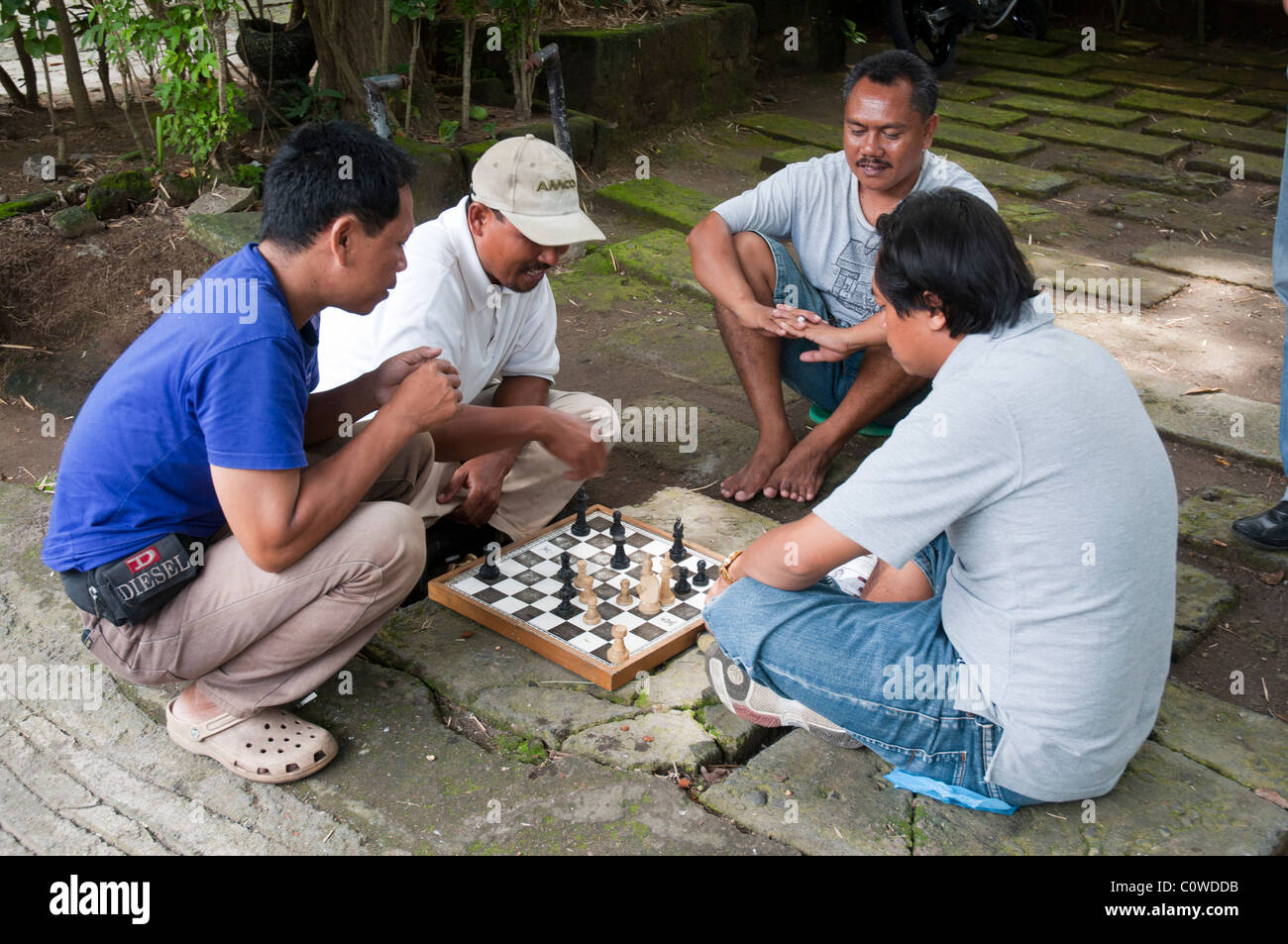 Hombres jugando un juego de ajedrez al borde de la carretera en Sanur, Bali, Indonesia Foto de stock
