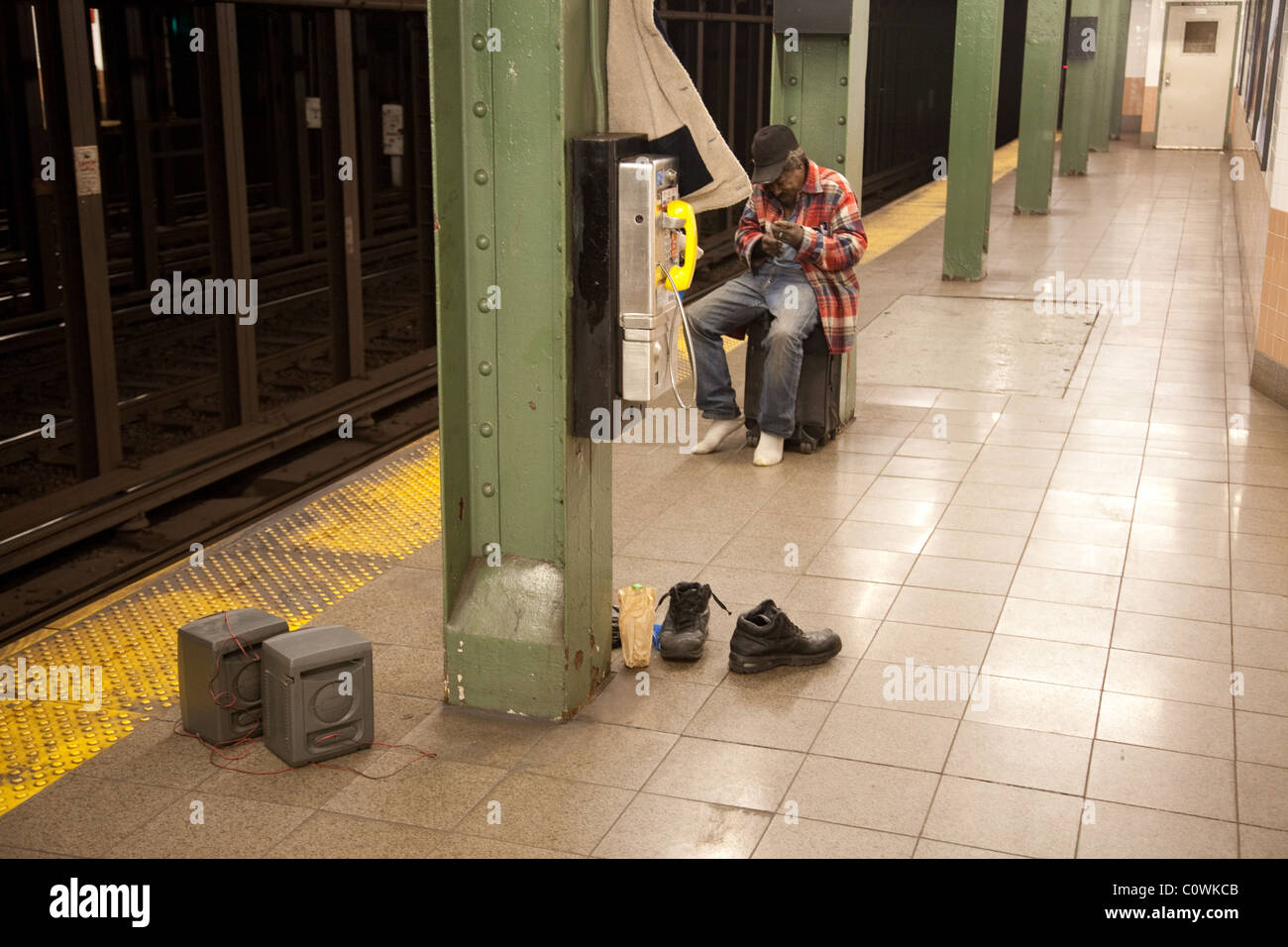 Hombre vagabundo en la estación de metro de Nueva York por un phonebox Foto de stock