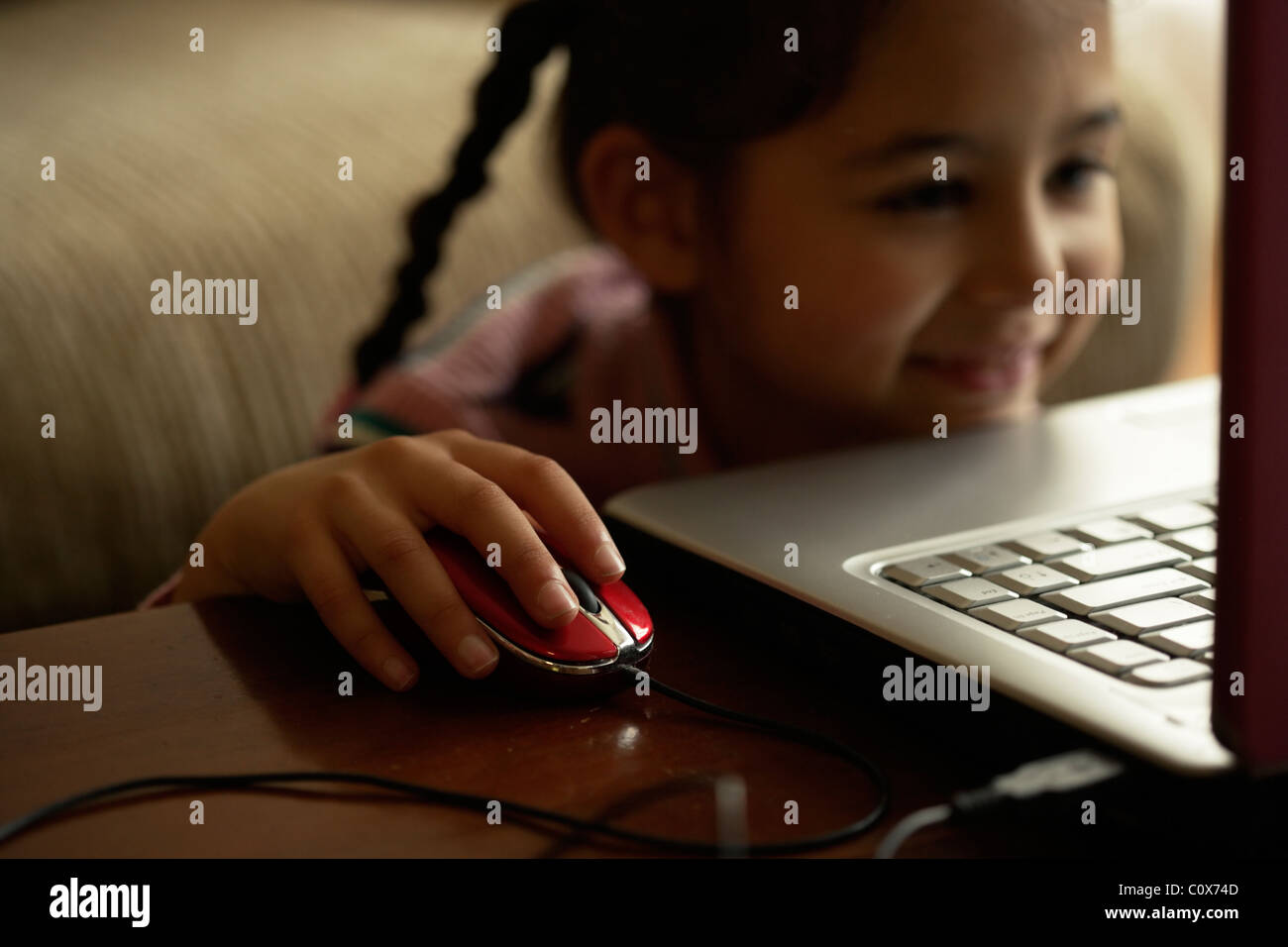 Chica utilizando el ratón del ordenador Foto de stock