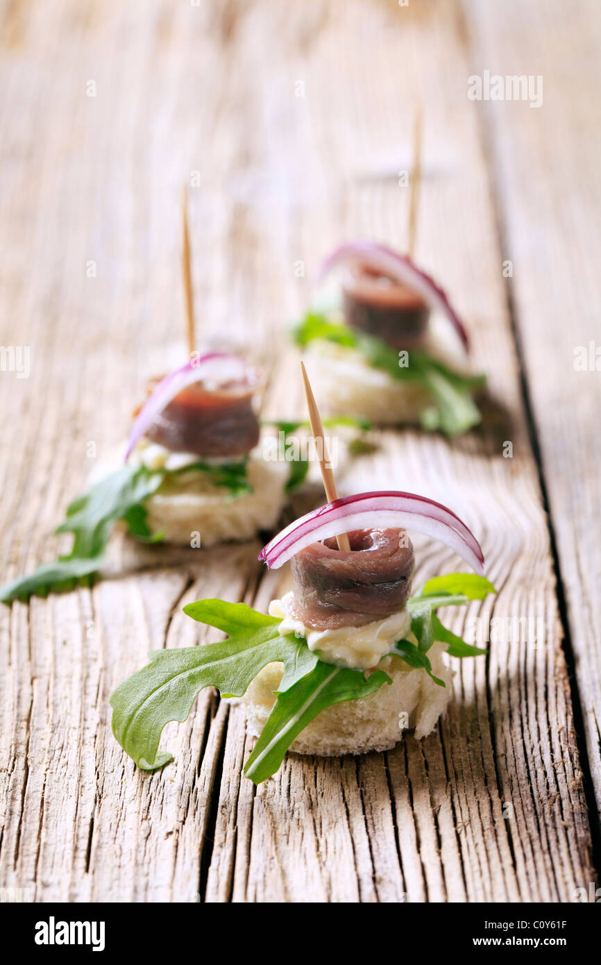 Canapés de anchoas aderezado con verduras y cebolla Foto de stock
