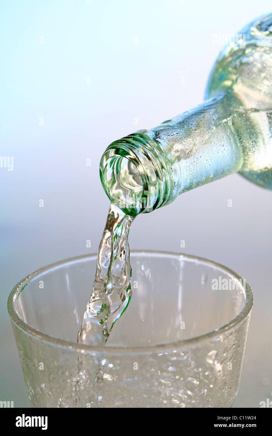 Botella de agua mineral y un vaso de agua, agua potable Foto de stock