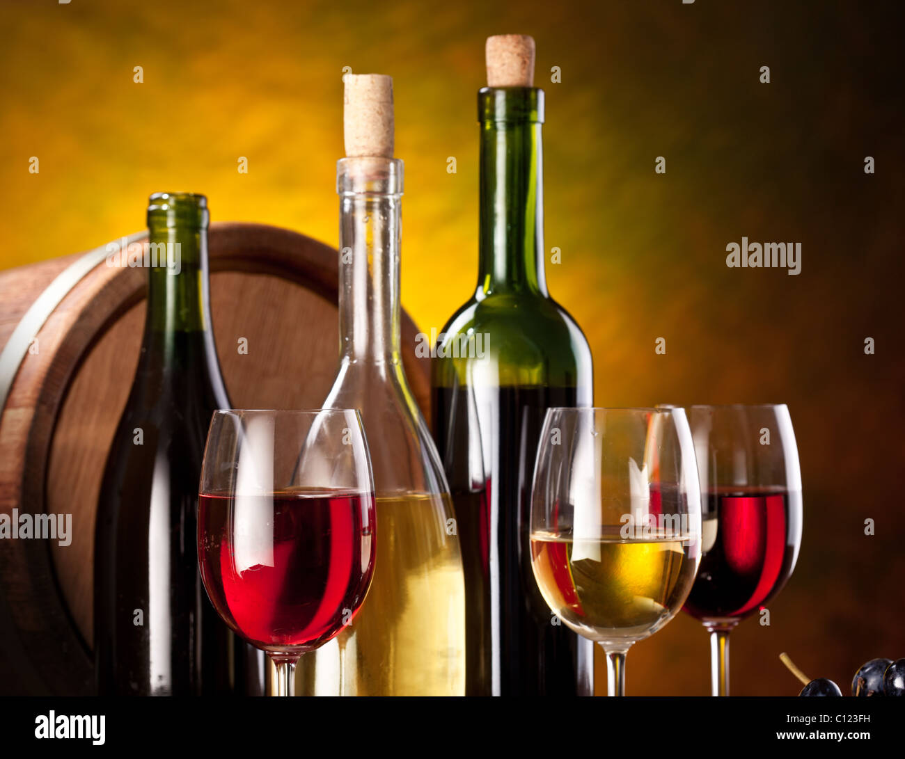 Bodegón con botellas de vino, vasos y barricas de roble. Foto de stock