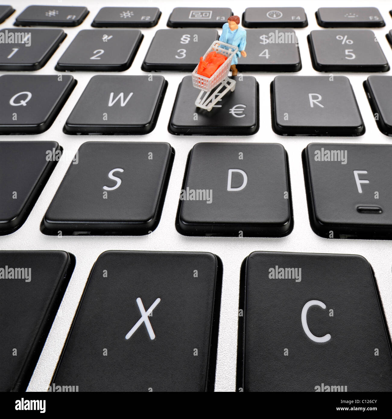 Figura en miniatura con el carro en el teclado, el símbolo del euro, imagen  simbólica para hacer compras en línea Fotografía de stock - Alamy