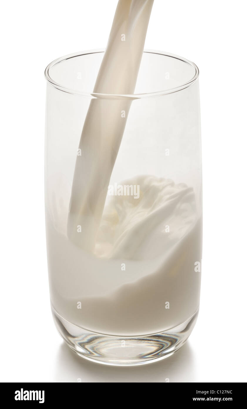 Splash de leche desde el cristal sobre un fondo blanco. El archivo contiene una ruta de acceso a la corte. Foto de stock