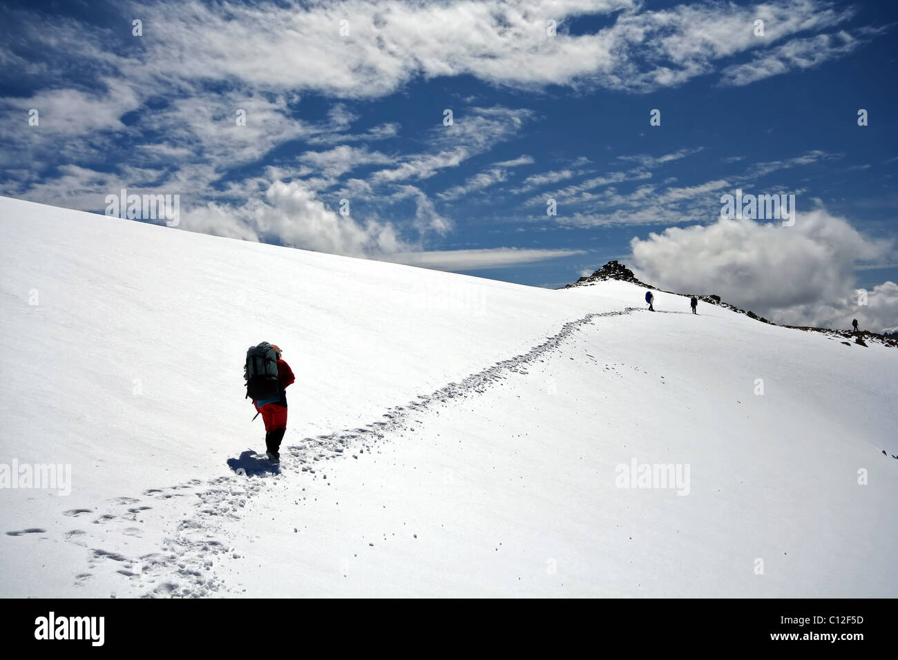 Los escaladores en la ladera de nieve en las montañas del Cáucaso. Área de Elbrus. Trazas a horizont. Escalada en las montañas. Foto de stock
