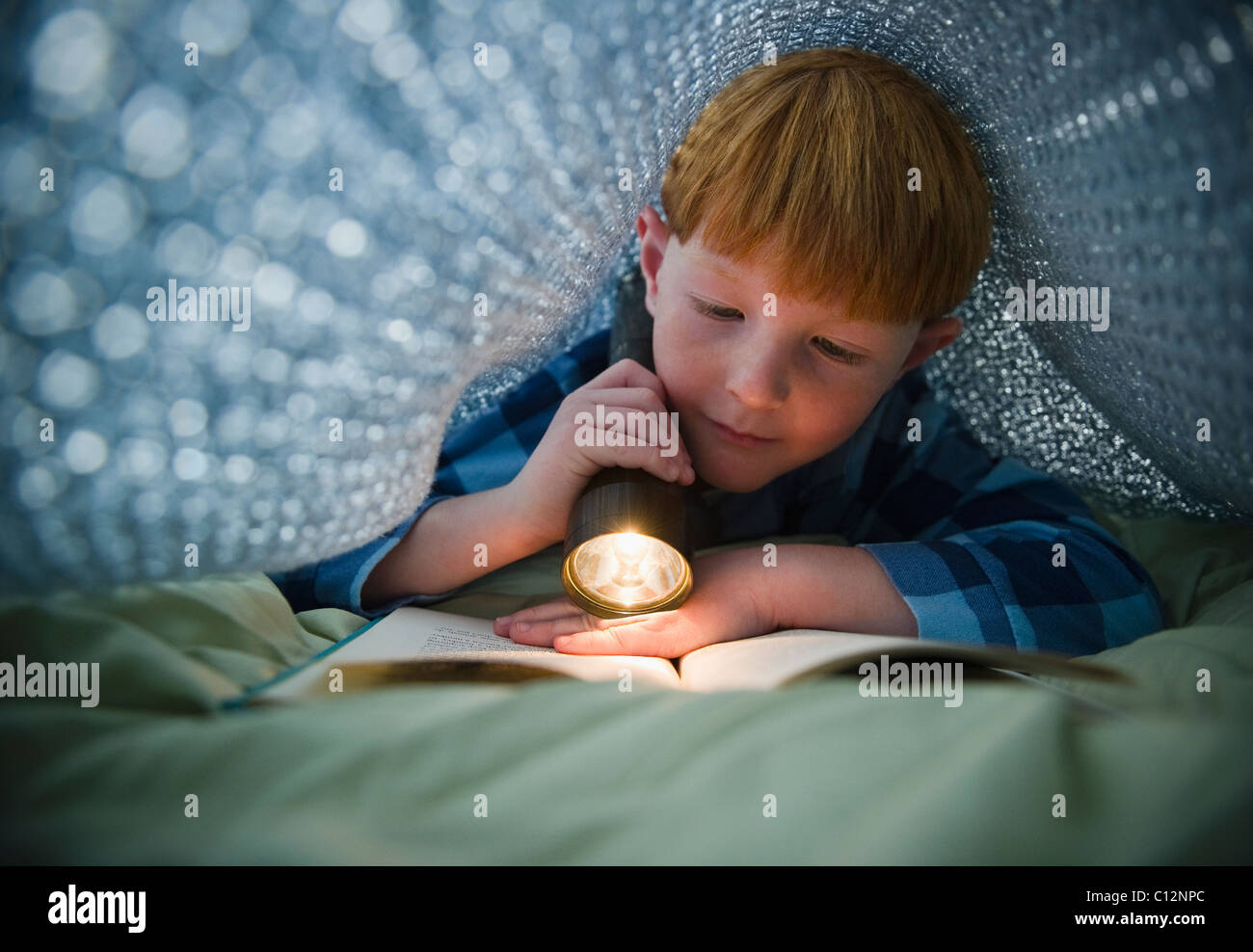 Los Estados Unidos, Nueva Jersey, Jersey City Boy (8-9) libro de lectura bajo la cama cubre Foto de stock