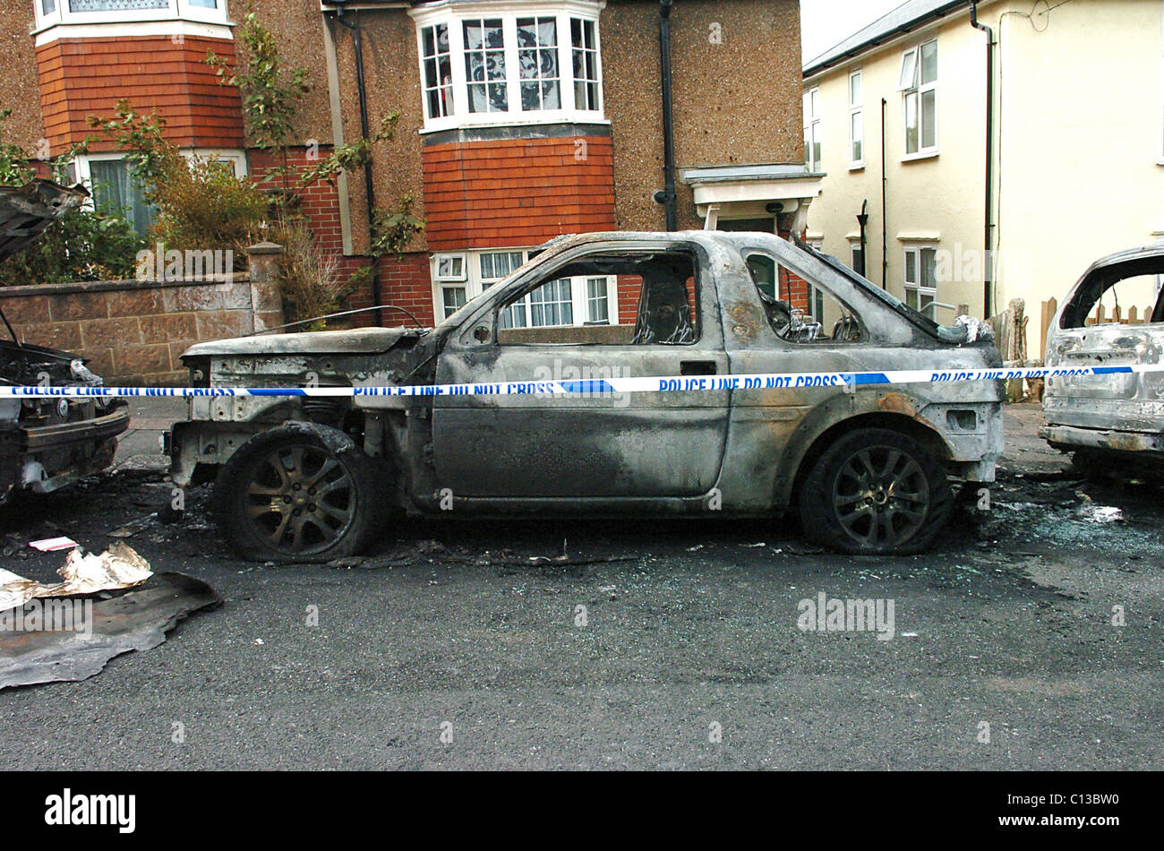 Restos de un automóvil incendiado tras un ataque incendiario en una calle residencial de Brighton Foto de stock