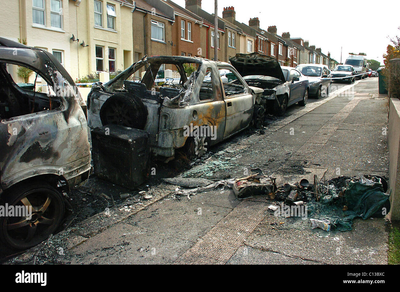Restos de varios coches quemados tras un ataque incendiario en una calle residencial de Brighton Foto de stock