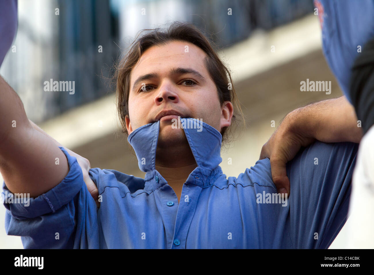 Participante en torre humana festival en Cataluña, España morder el collar por fuertes músculos en el cuello Foto de stock