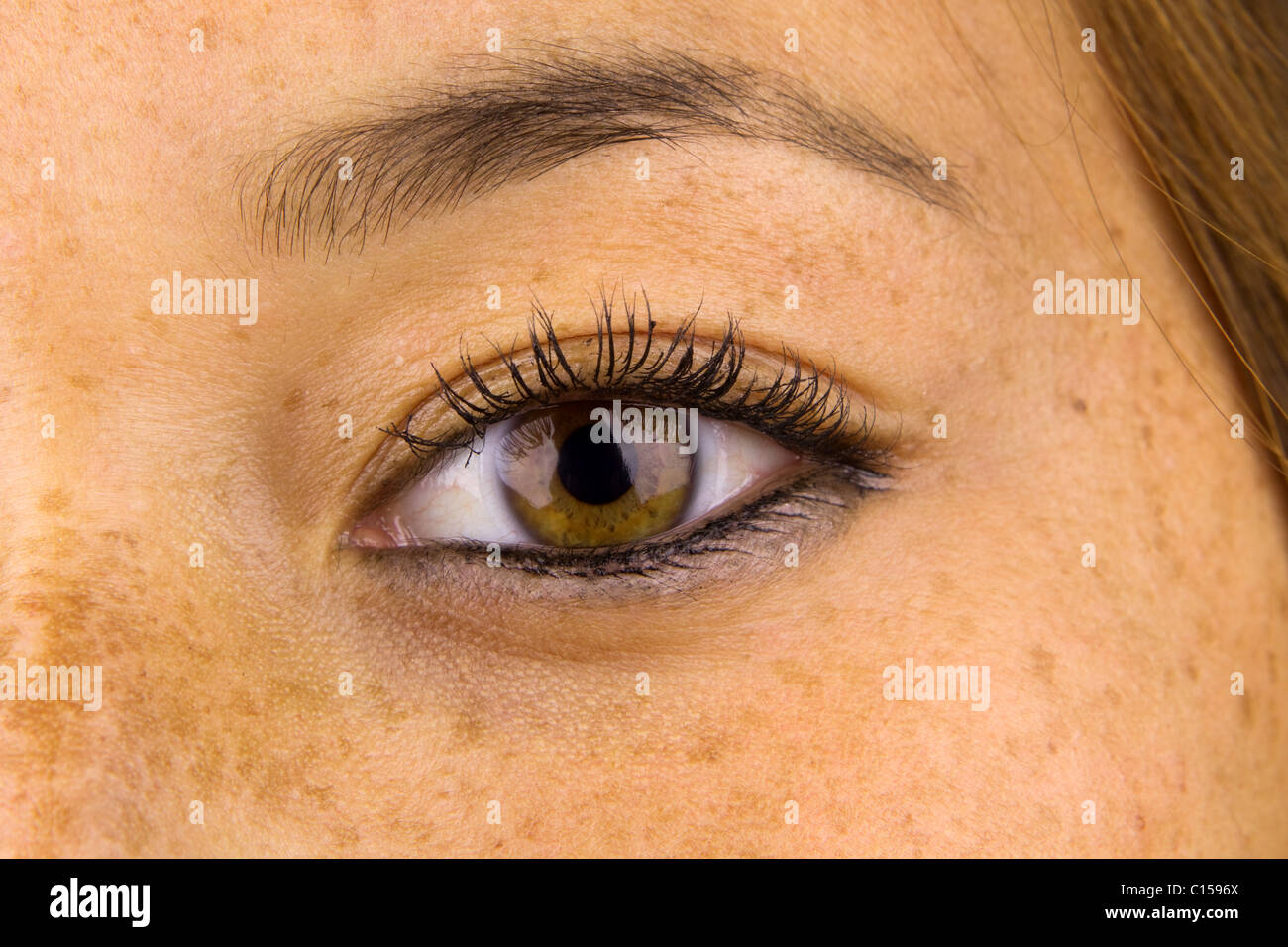 Cerrar los ojos de la mujer y la piel circundante mostrando el daño solar, conocido comúnmente como pecas. Foto de stock