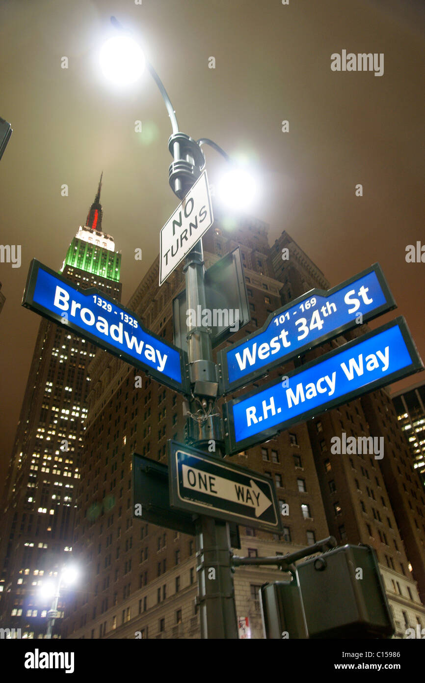 Los letreros de la calle debajo del Empire State Building en Midtown Manhattan Foto de stock