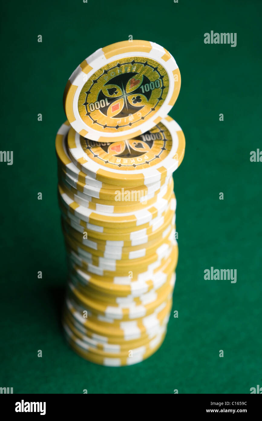 Fichas de póquer amarillo, apiladas en fieltro verde Foto de stock