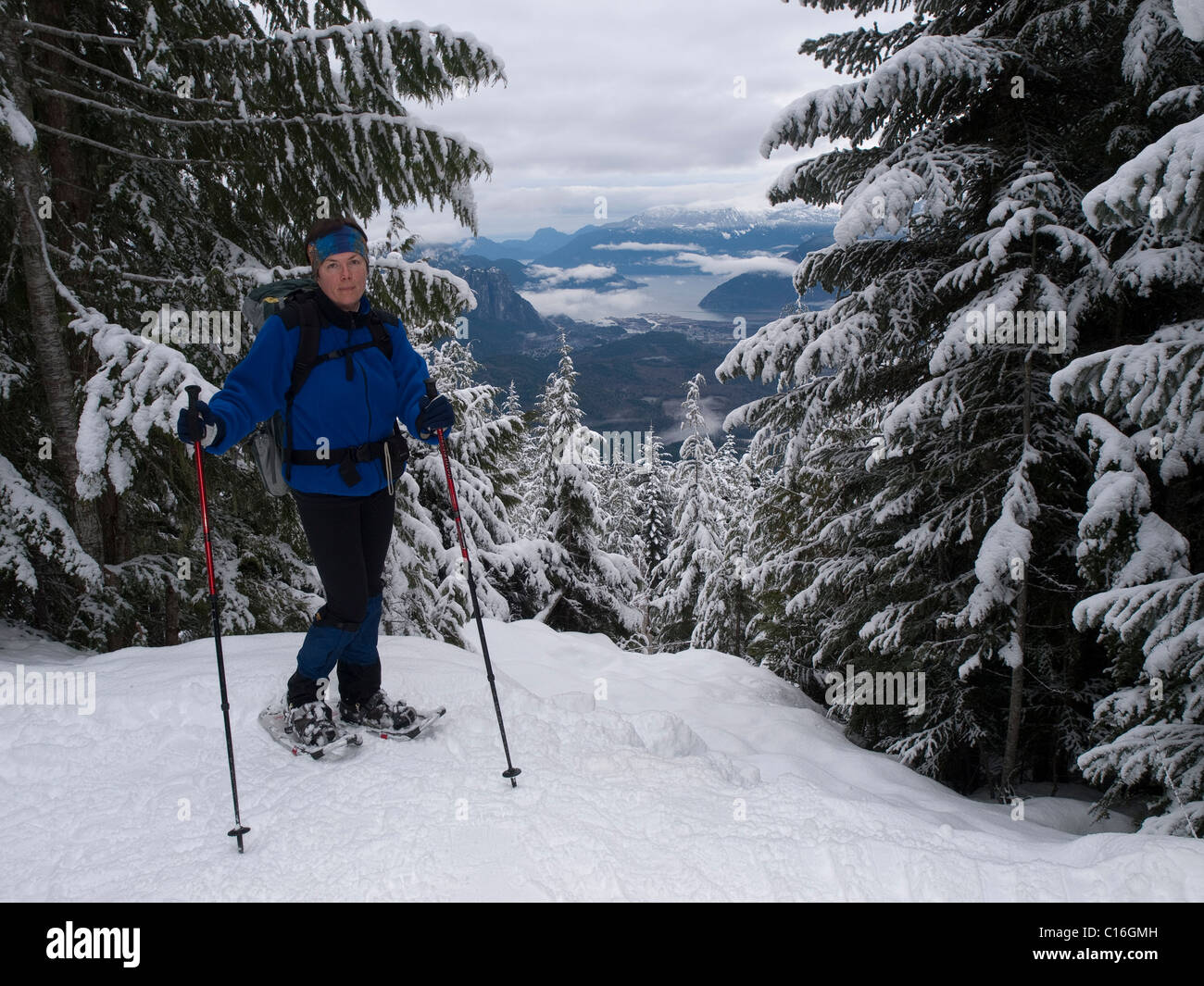 Ms snowshoeing relajarse en la perspectiva hacia el valle. Foto de stock