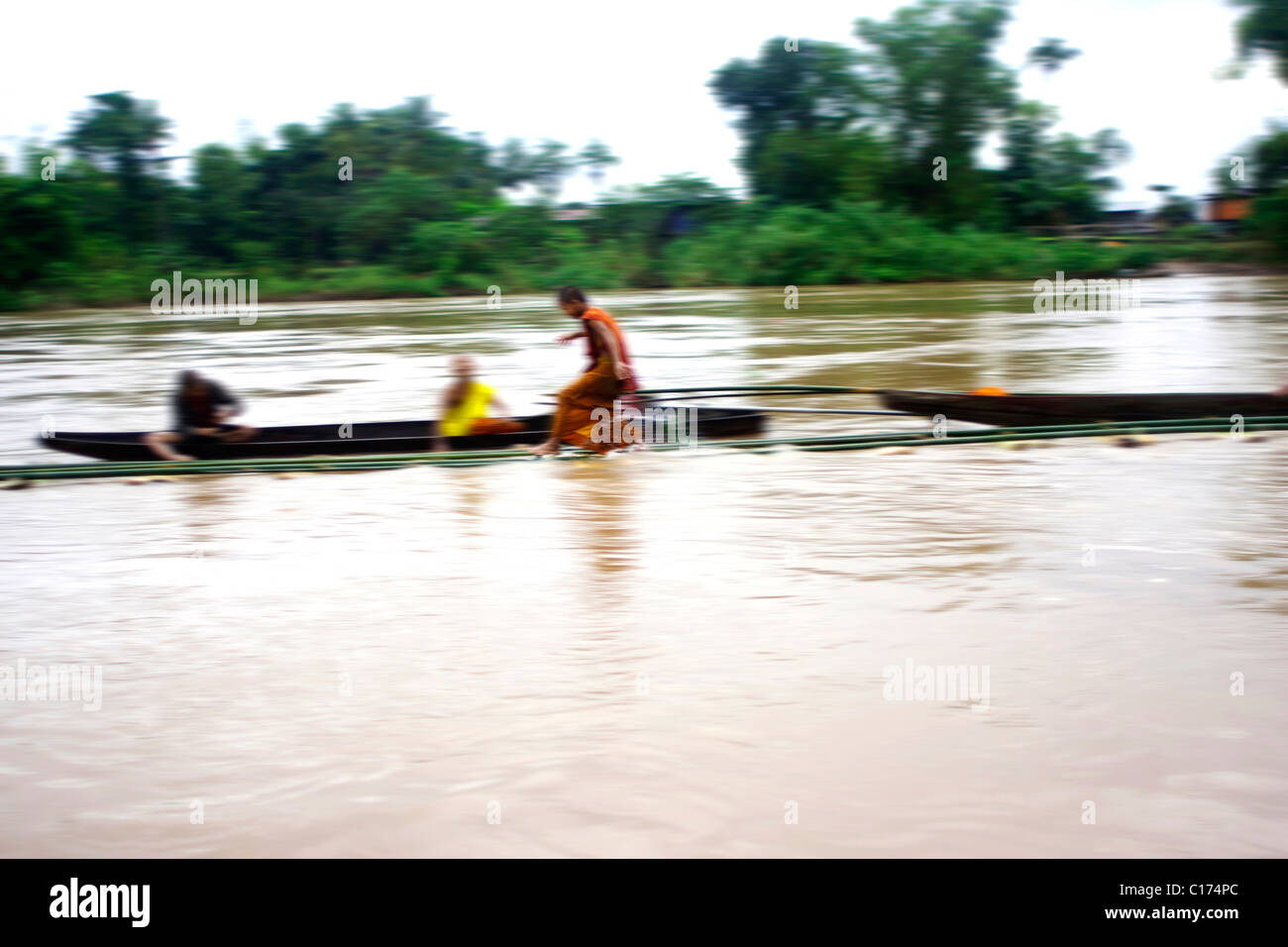 Monje jugando en el agua del río Mekong en Si Phan Don, 4 mil islas, Laos Foto de stock