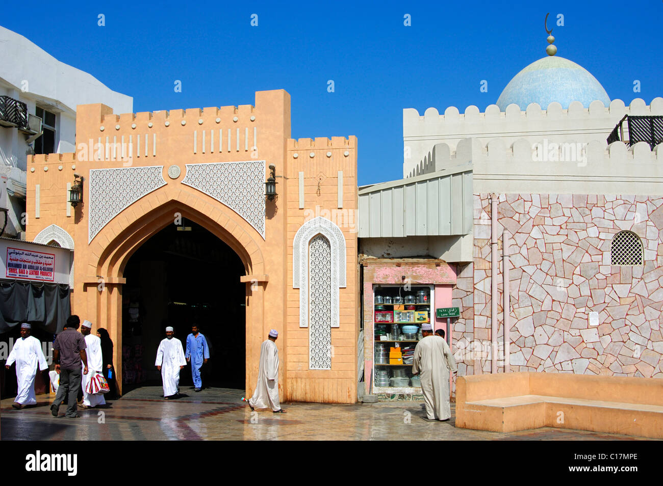 Los residentes locales vestidos con ropas tradicionales en la puerta de entrada al Zoco Muttrah mercados, Muscat, Omán, el Cercano Oriente Foto de stock