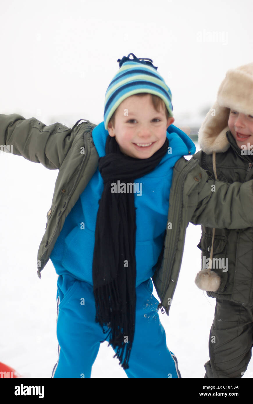 Chicos de remolque en la nieve. Foto de stock