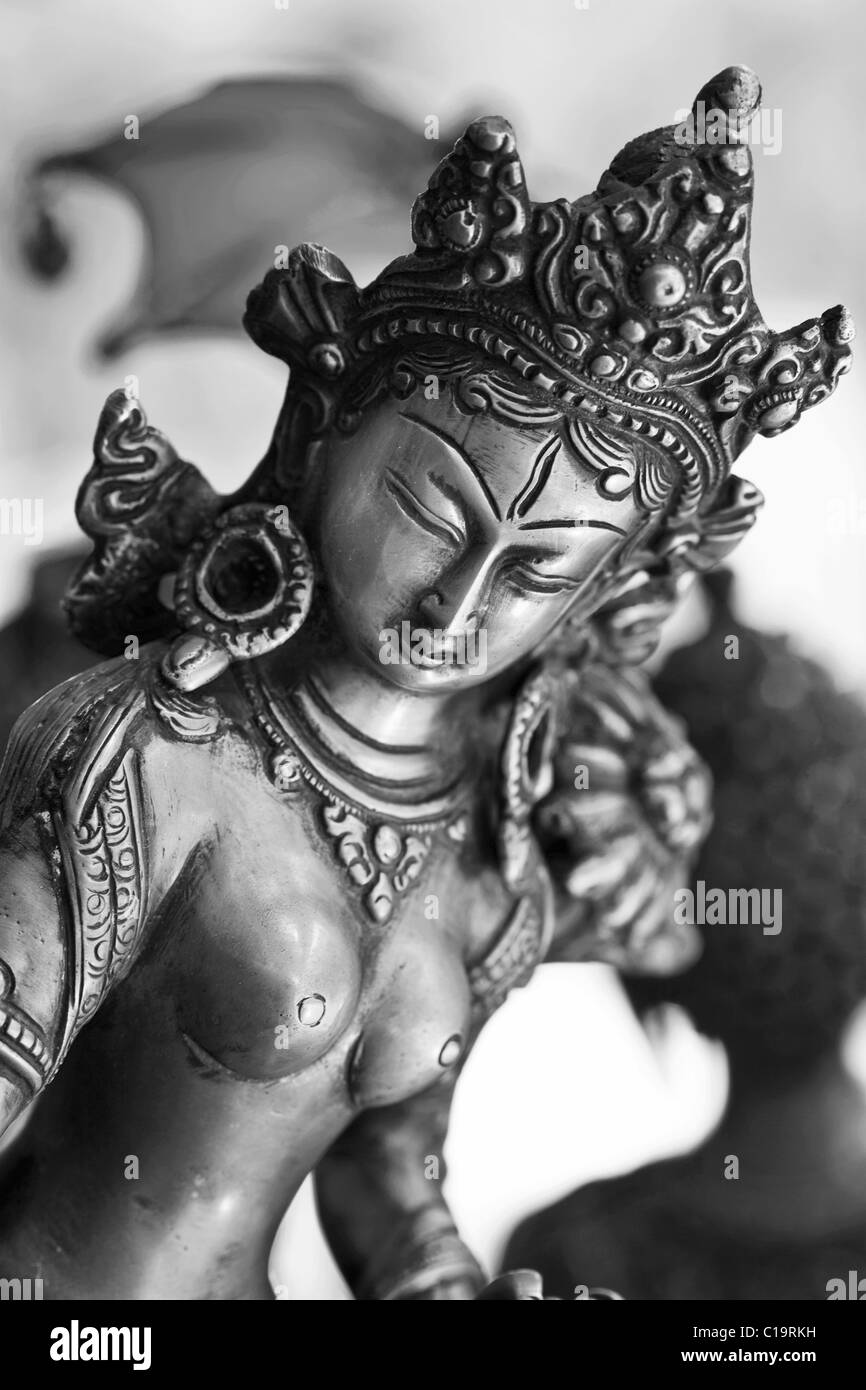 Metallic Estatua de la Diosa budista tibetano Tara (de mano Tamaño ) en una tienda, Puttaparthi, en el sur de la India - Blanco y Negro. Foto de stock