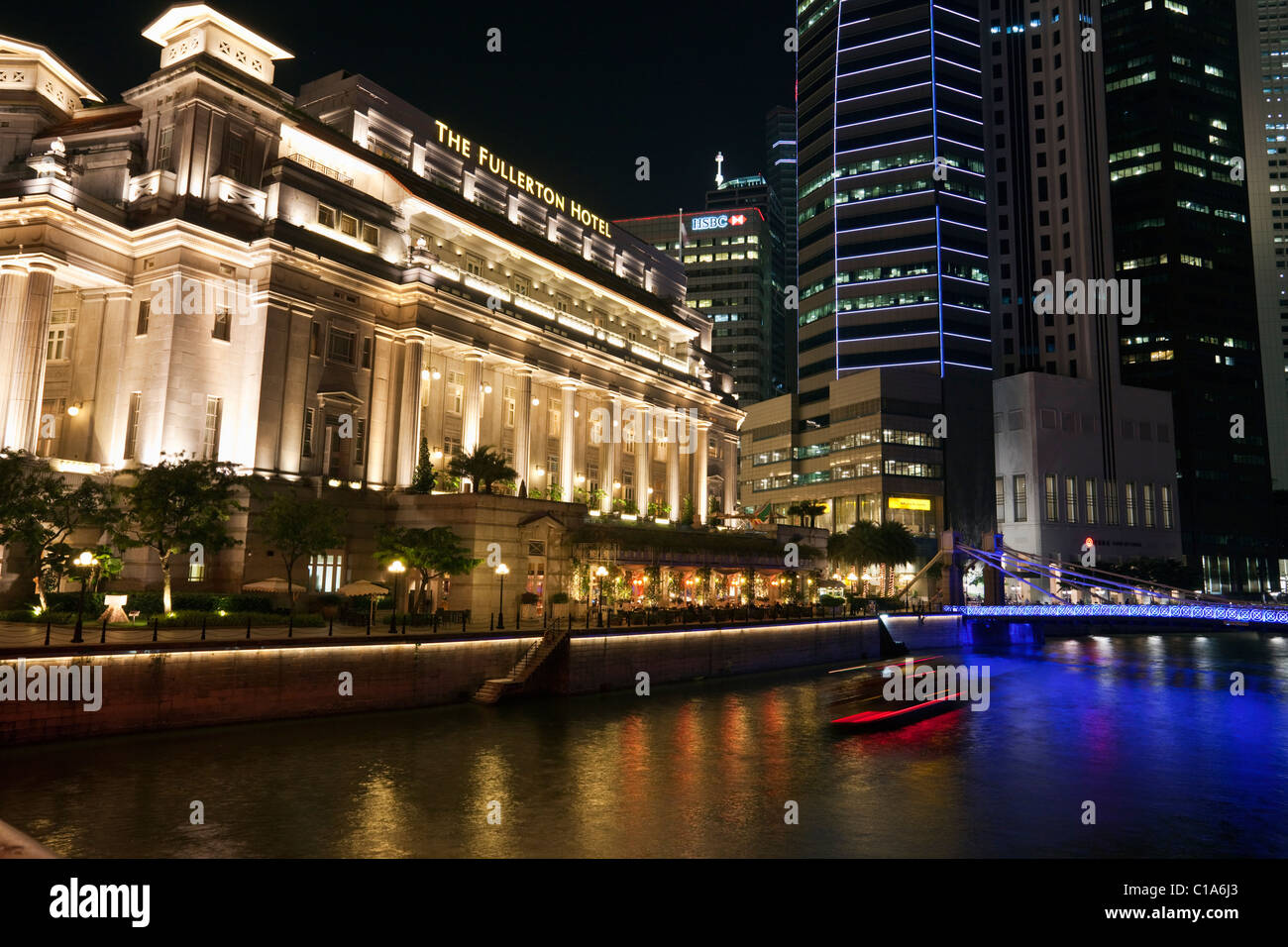 El Hotel Fullerton e iluminado en la noche por el río Singapur, Singapur Foto de stock