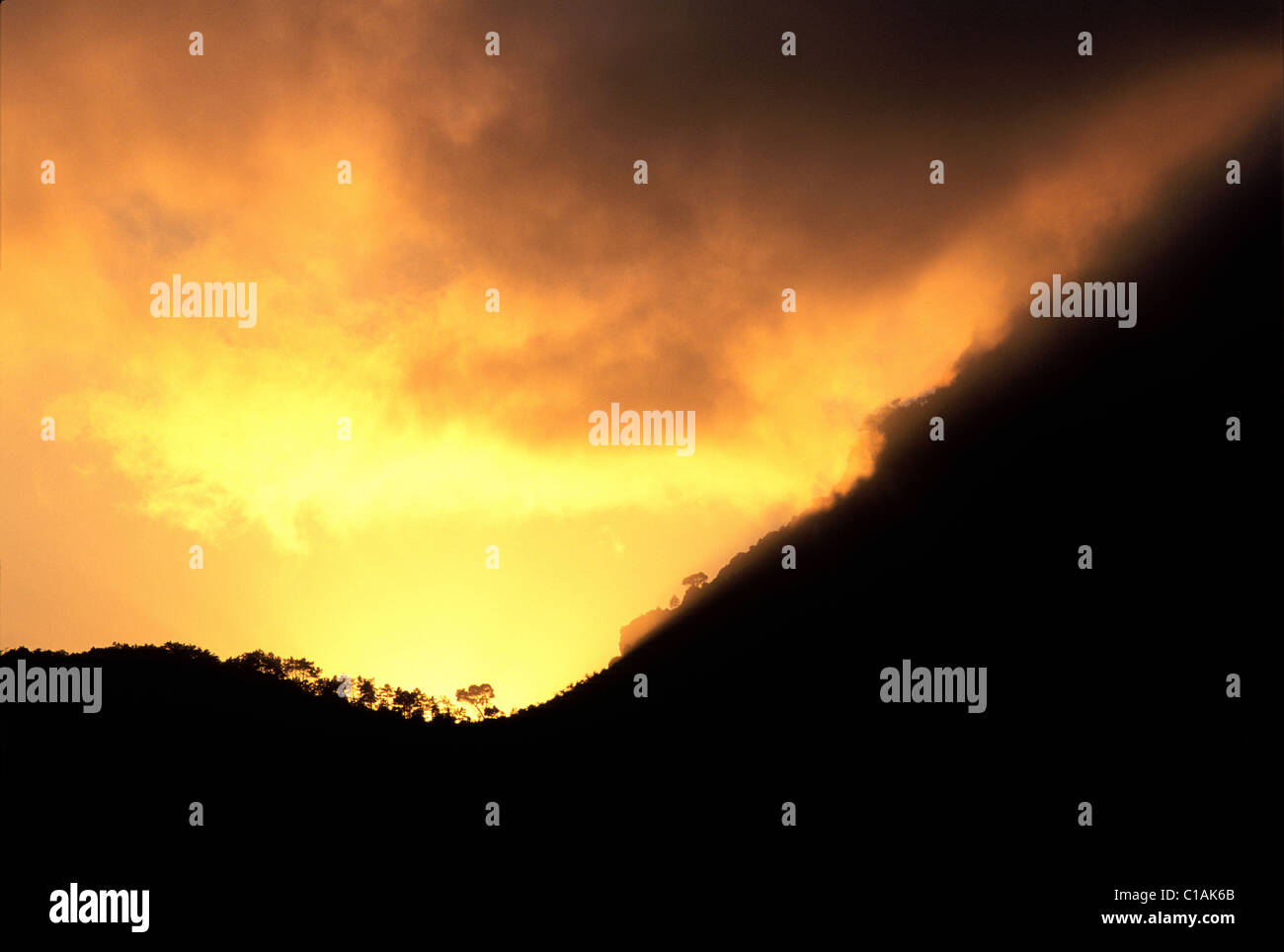 Francia, Alpes Maritimes, puesta de sol que hace montaña roja detrás de Gilette village Foto de stock