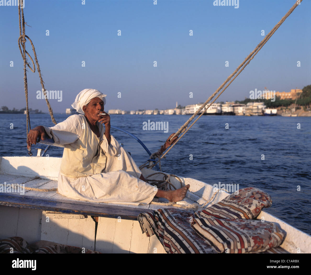 Dirección hombre local faluca por el río Nilo, en Luxor, Egipto Foto de stock
