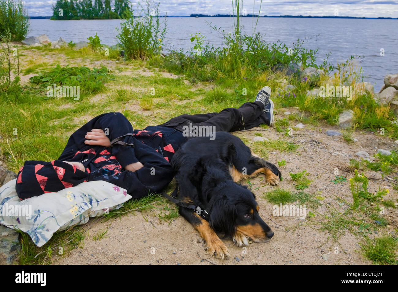 Adolescente y su perro por el lago Hjalmaren en Suecia. Foto de stock