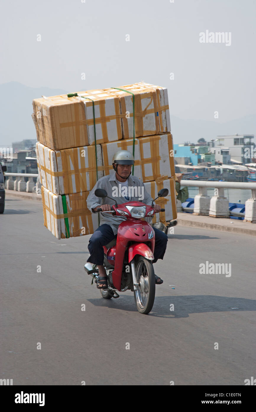 Hombre en motocicleta con el montón de grandes cajas de cartón Foto de stock