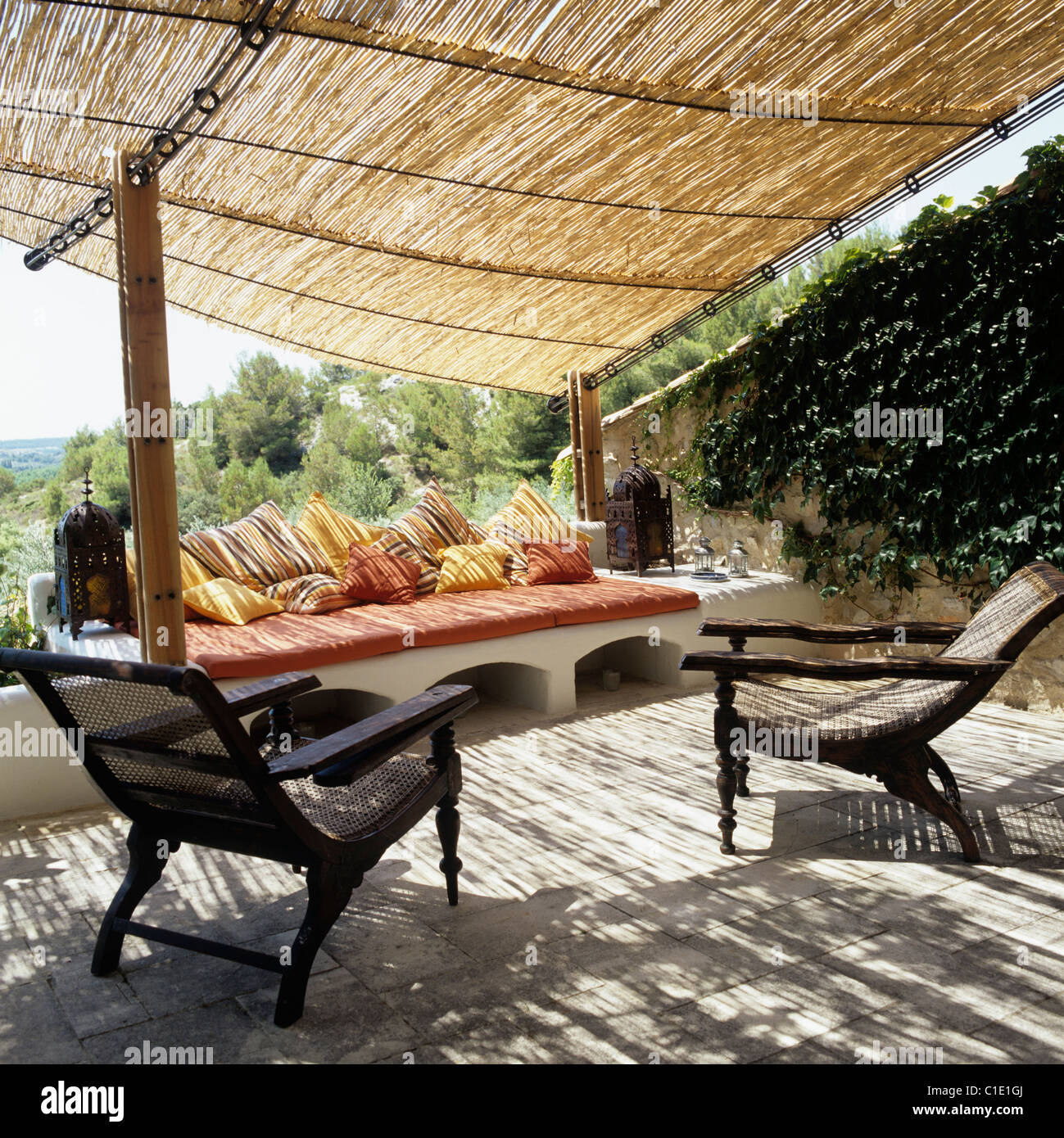 Sillones de madera y asientos con almohadones en terraza con toldo de bambú  y rural vistas provenzal Fotografía de stock - Alamy