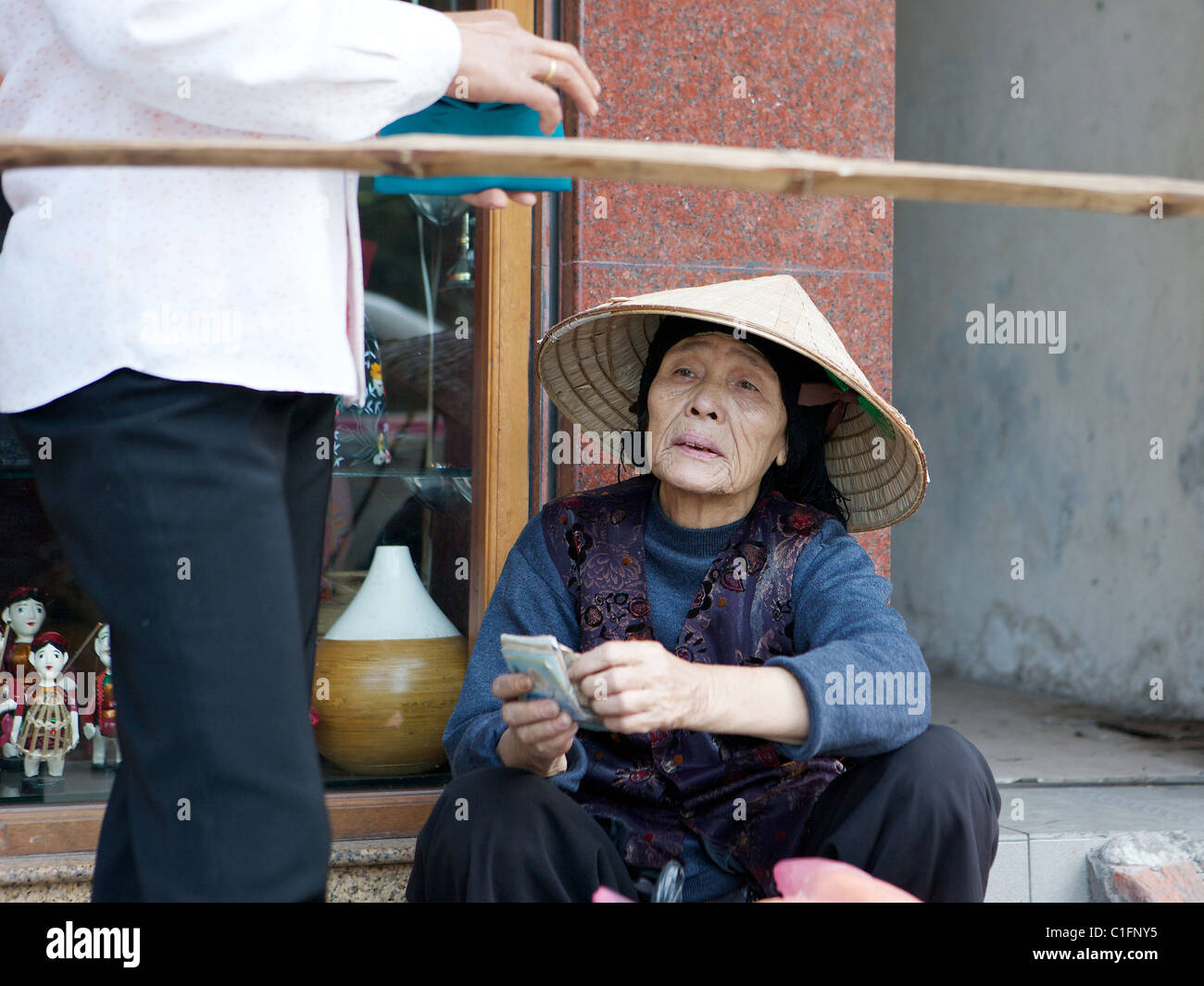 Retrato de la calle vieja en un sombrero cónico de la tradicional no en Hanoi, Vietnam Foto de stock