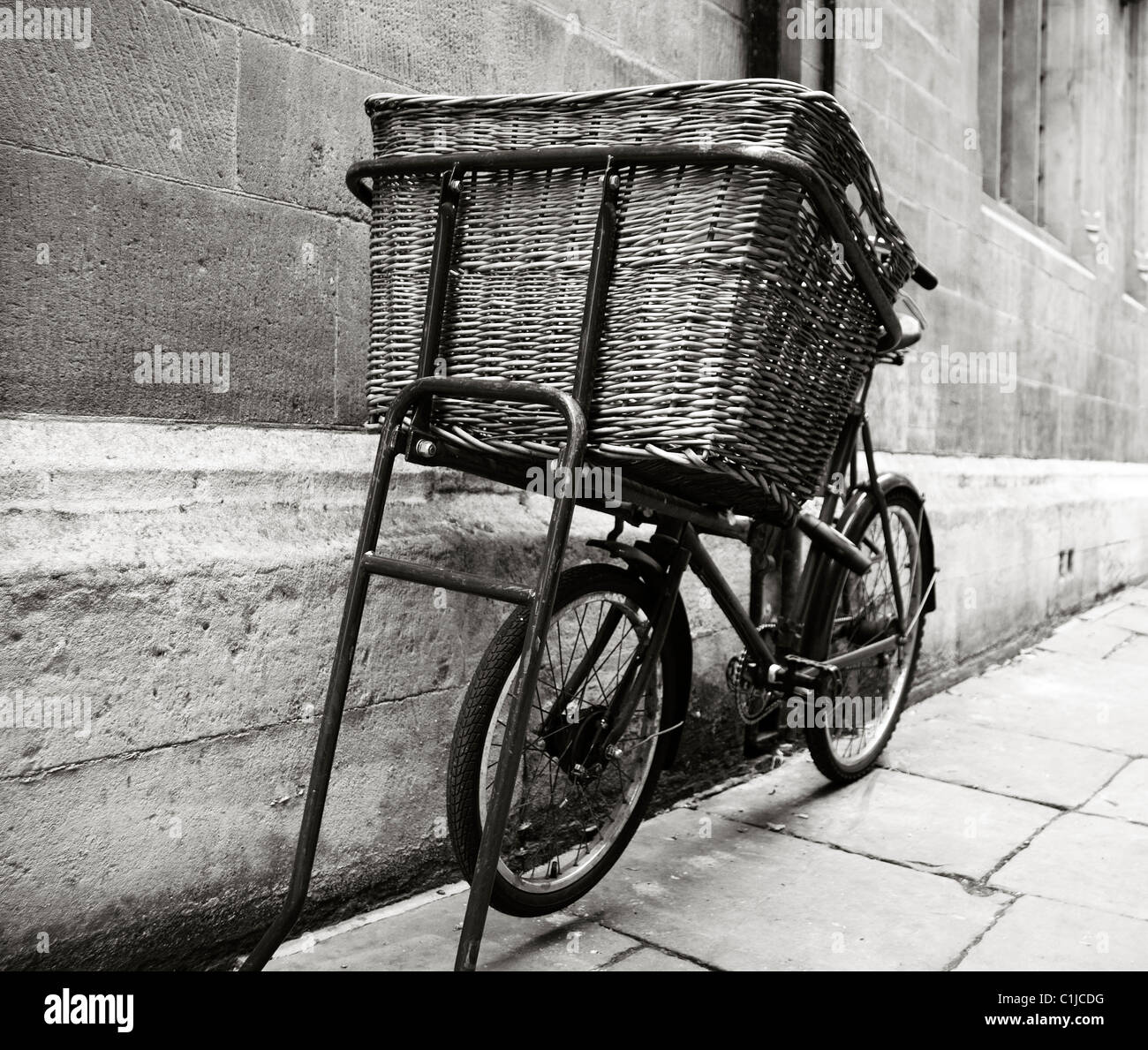 Bicicletas antiguas en blanco y negro con gran entrega cesta en la ciudad Foto de stock