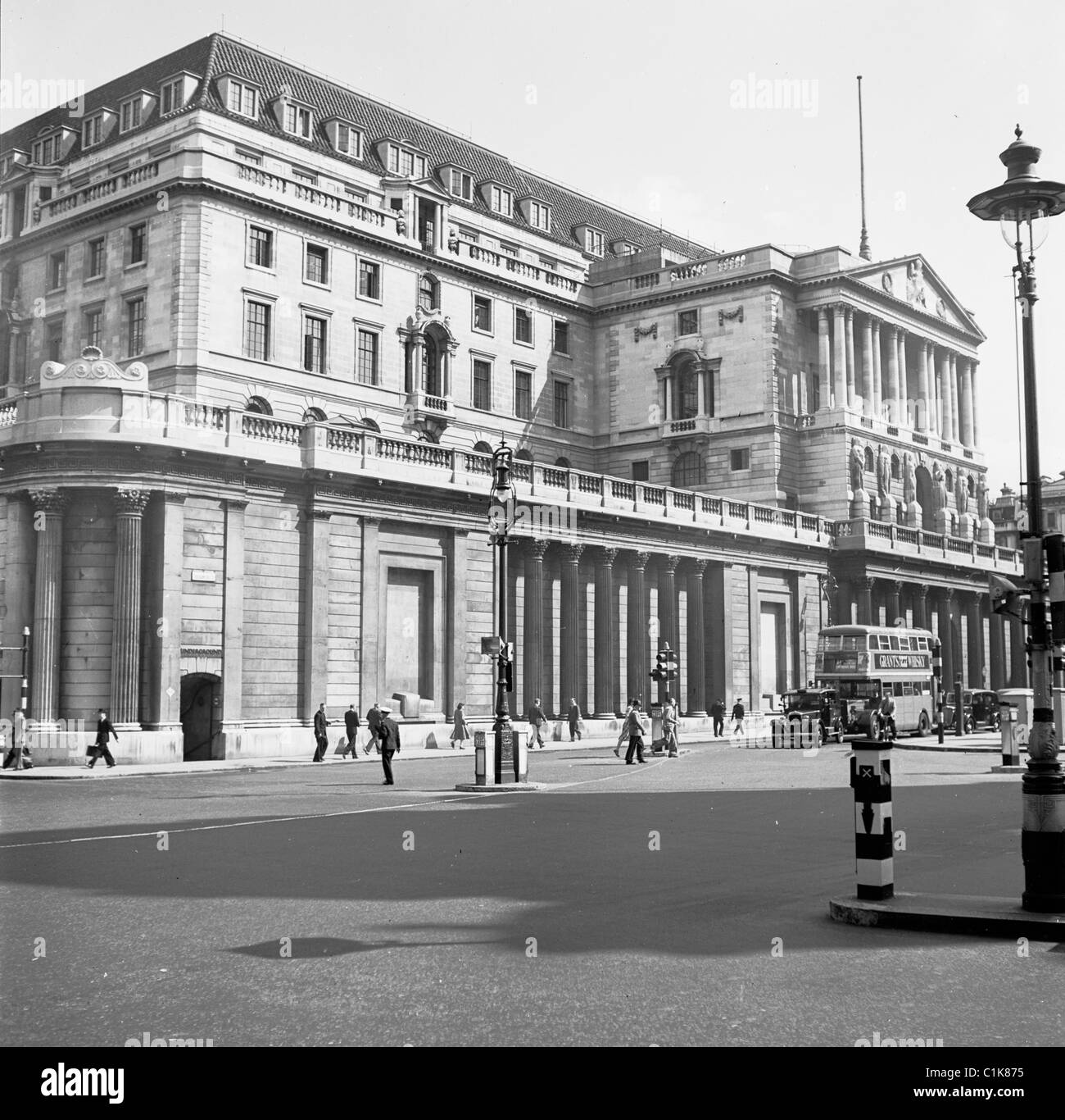 1950s, el exterior del Banco de Inglaterra en Threadneedle Street, City of London, con personas y vehículos del día, incluyendo un autobús routemaster. Foto de stock