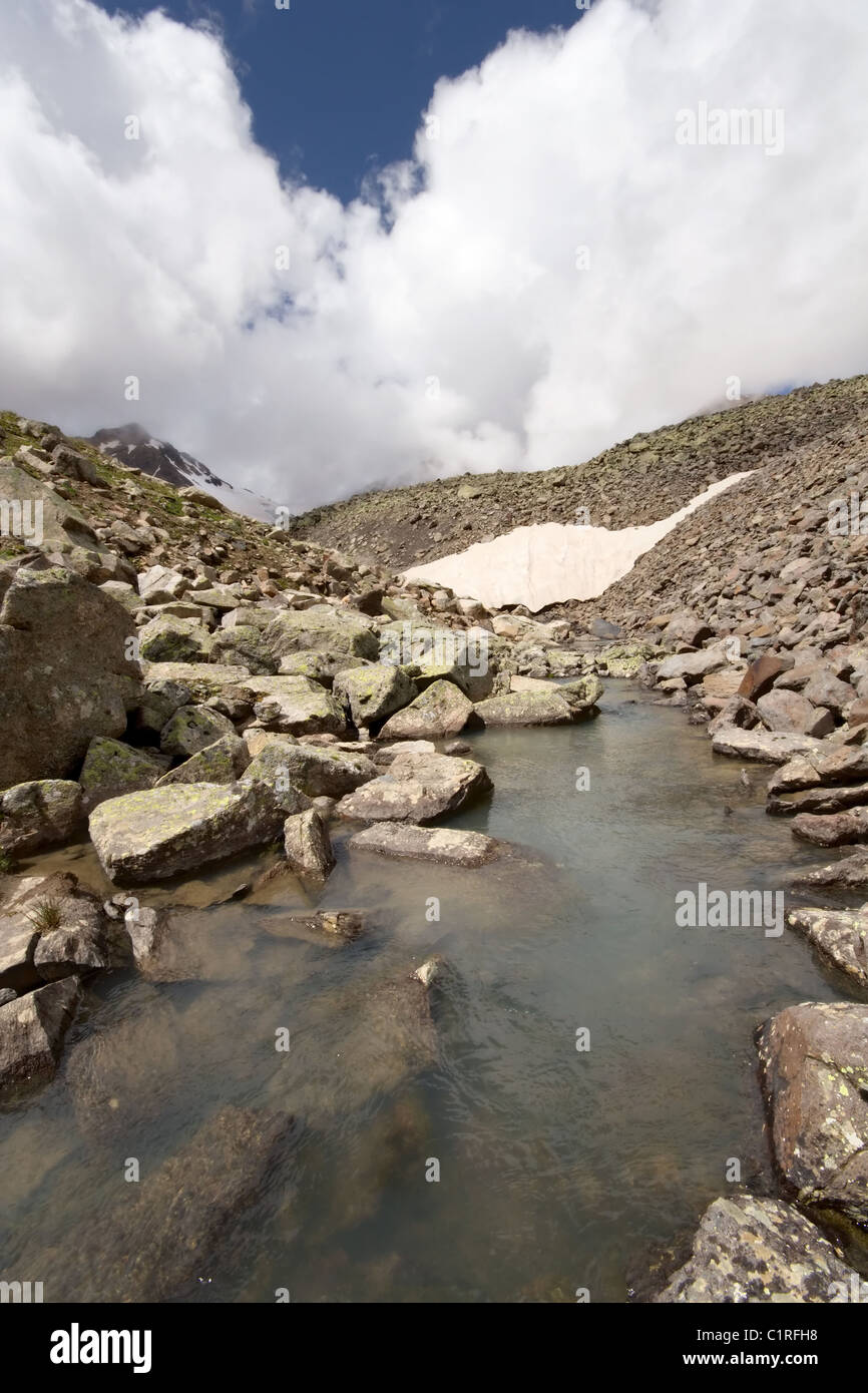 Lago glaciar en montañas del Cáucaso. Las nubes y la niebla. Kabardino-Balkaria. Rusia. Foto de stock