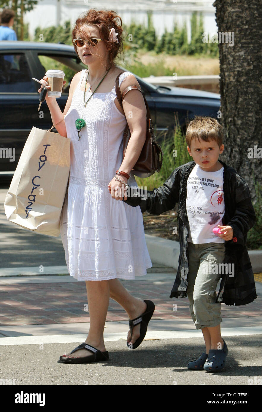 Helena Bonham Carter dejando 'juguete Loco' con su hijo Billy Ray Burton, que llevaba una gran bolsa de compras y un café en Malibu. Foto de stock