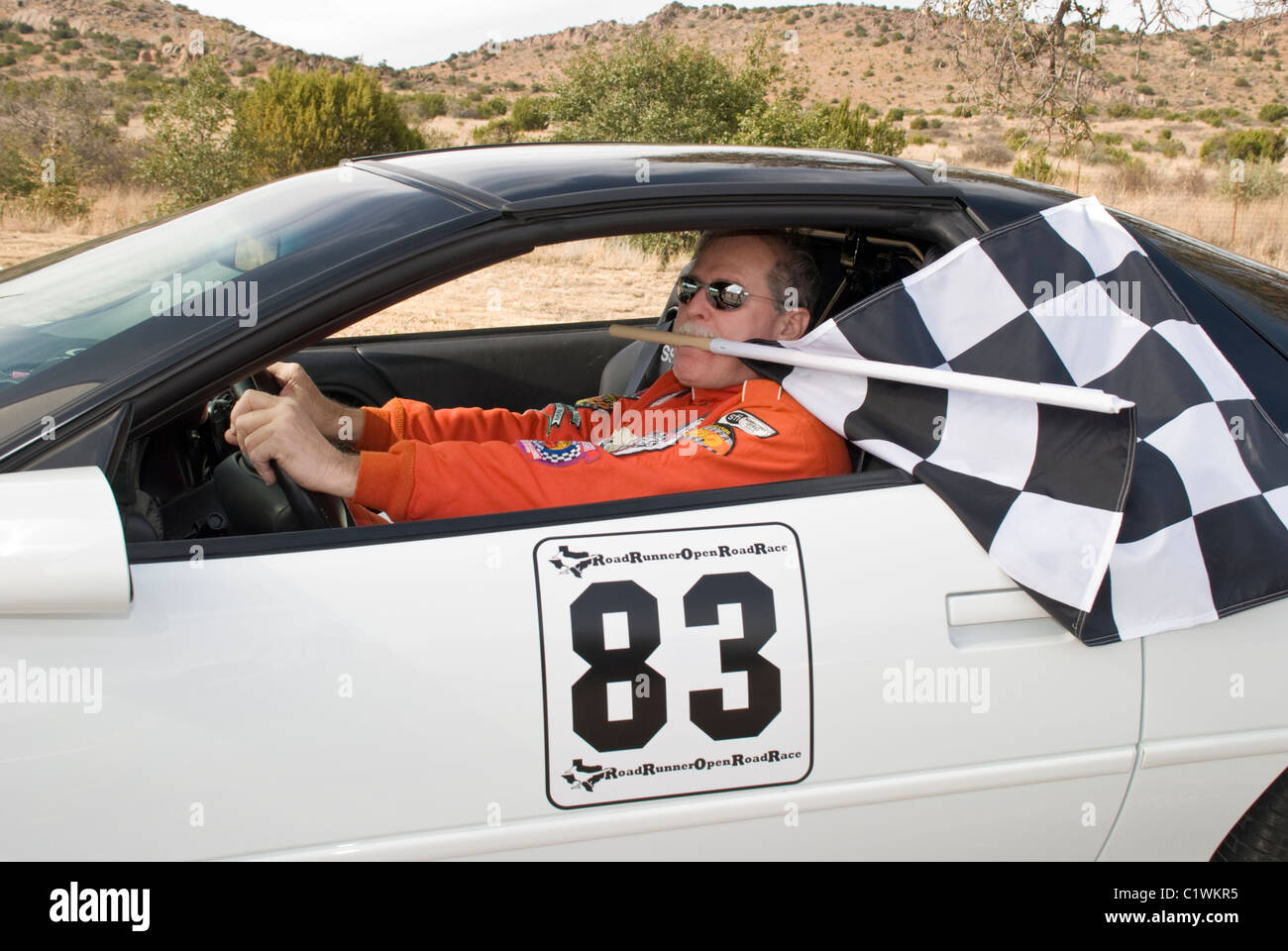 Conductor de autos de carrera Mike Poderes, poderes Automotive Racing Team,  garantiza una ganancia por llevar su propia bandera ! Alpine, Texas  Fotografía de stock - Alamy