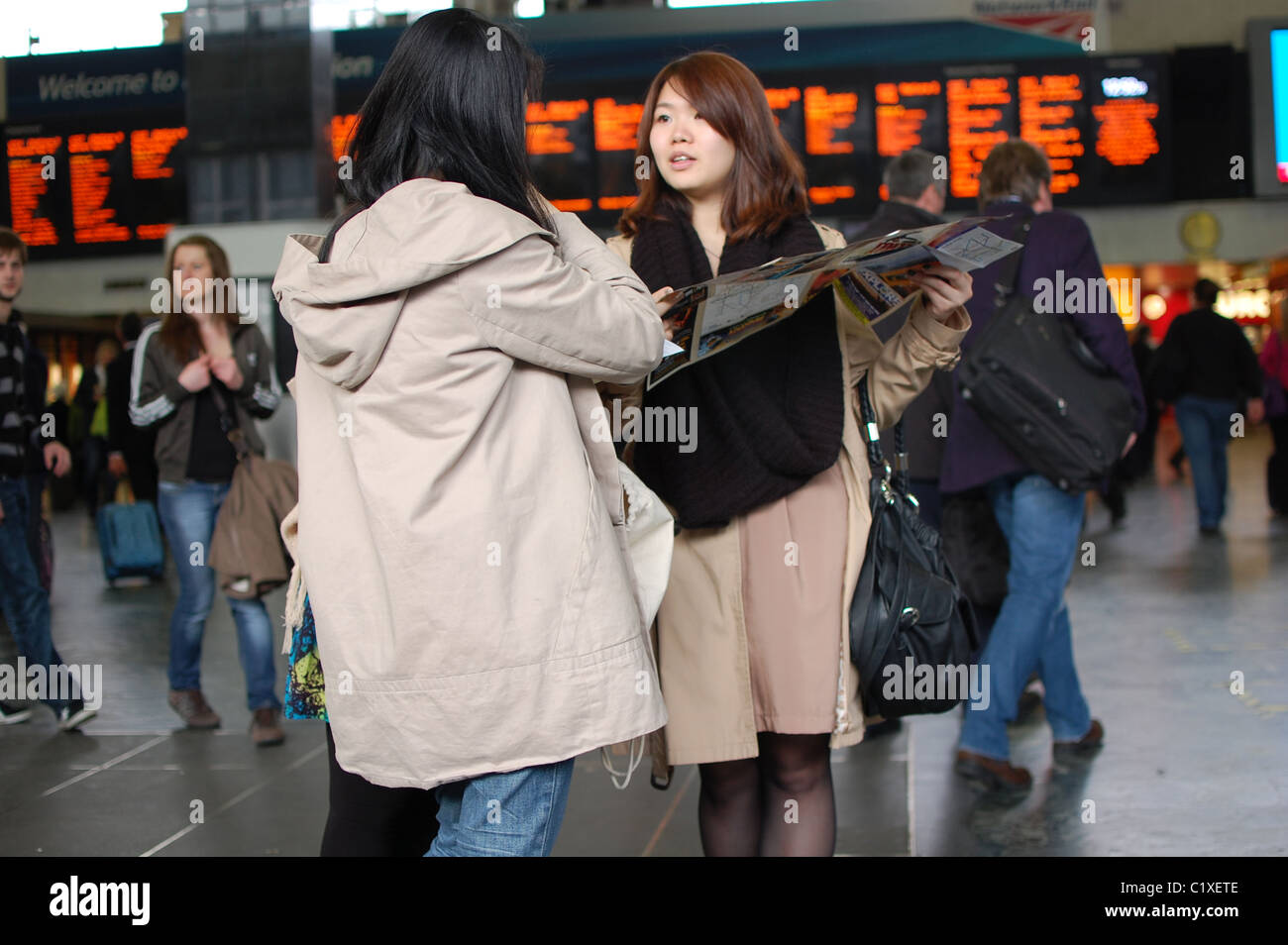 Los turistas mostrando un mapa en London Euston Station Foto de stock