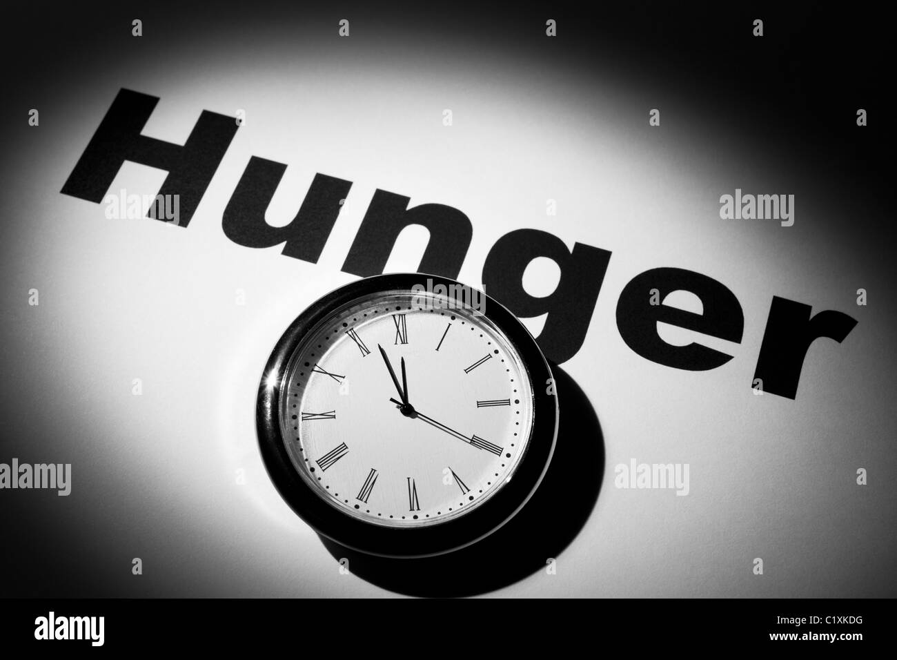Reloj y palabra de hambre de fondo Foto de stock