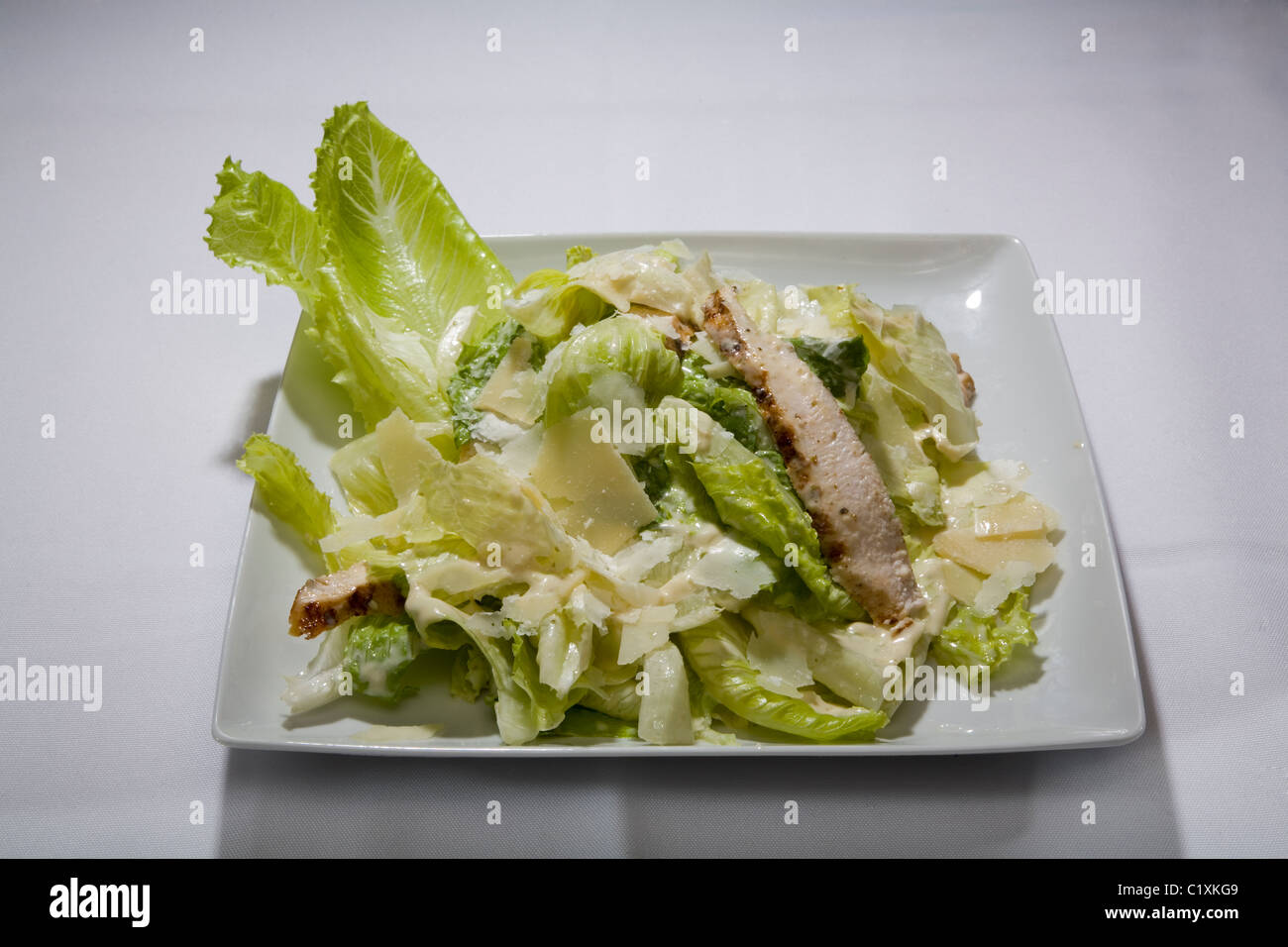 Ensalada de Pollo lechuga verde plaza vegetal placa blanca comida ligera cocina mediterránea mantel aderezo ligero apetito mea Foto de stock