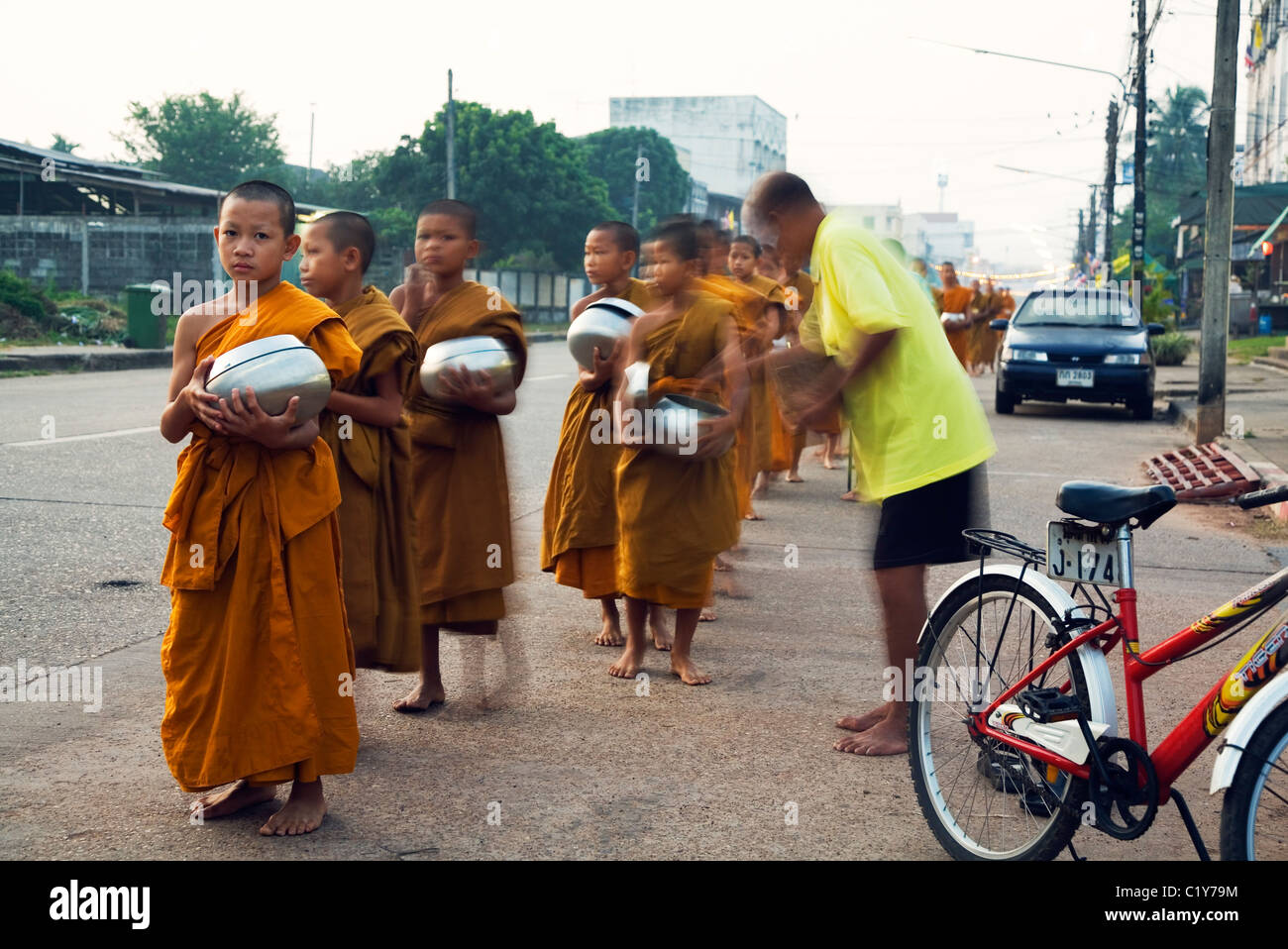 Jóvenes monjes mañana recibir limosnas de los budistas tailandeses, haciendo mérito. De Nakhon Phanom, Nakhon Phanom, Tailandia Foto de stock