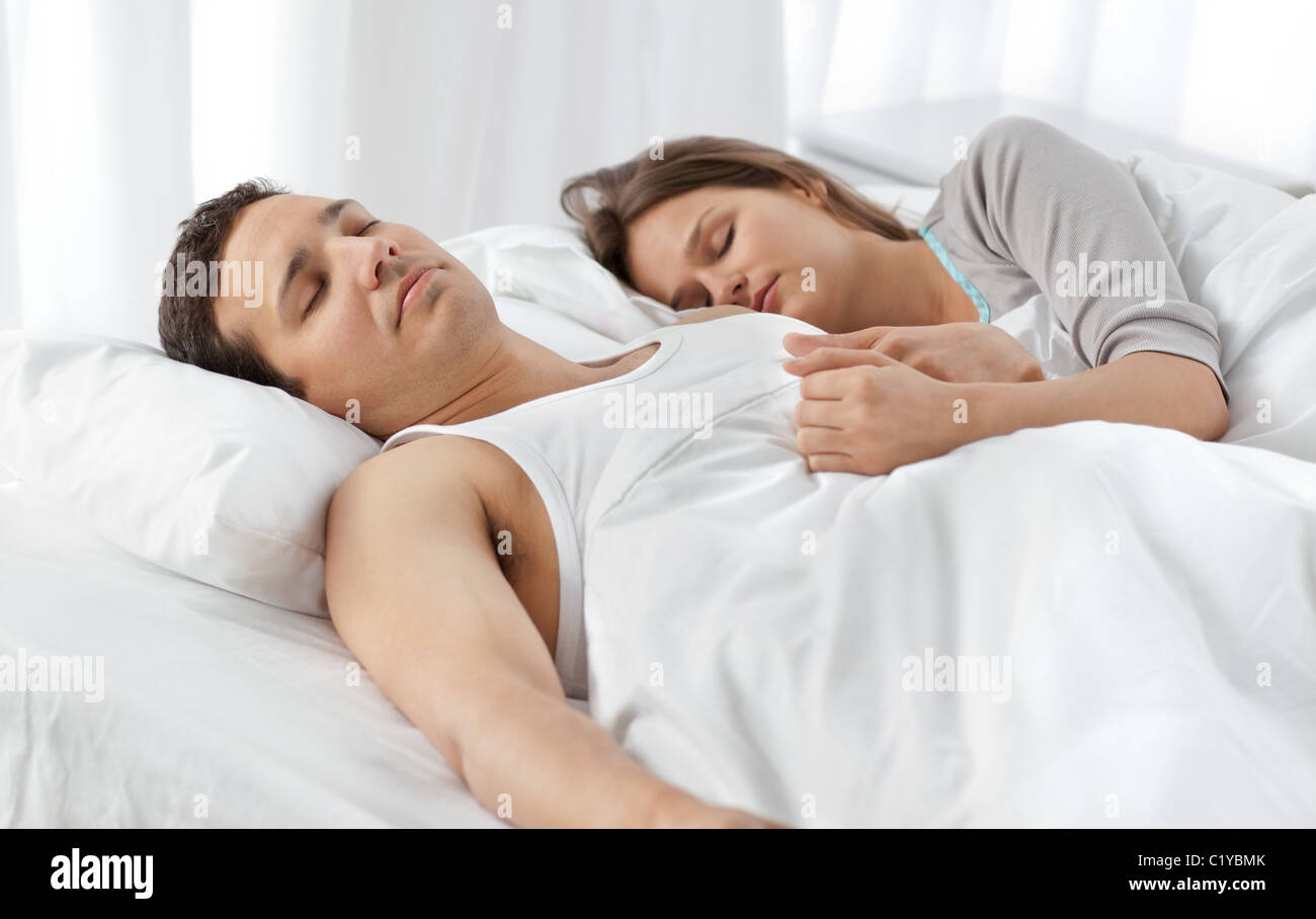 Linda pareja durmiendo juntos en su cama Fotografía de stock - Alamy
