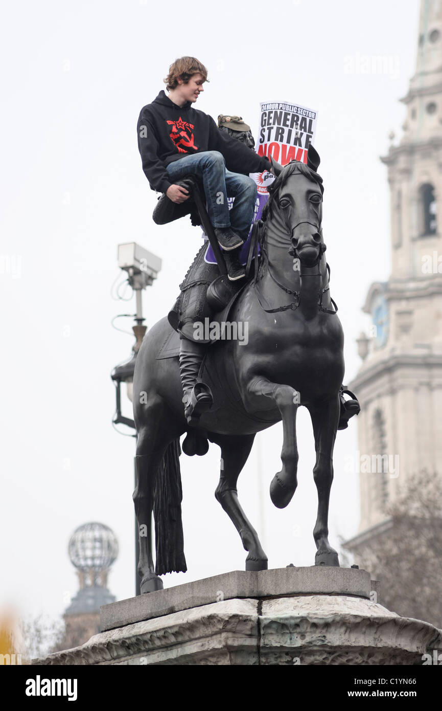 Manifestante en estatua en Trafalgar Square, la TUC Anti-Spending Cortes de marzo, Londres, 26 de marzo de 2011 Foto de stock