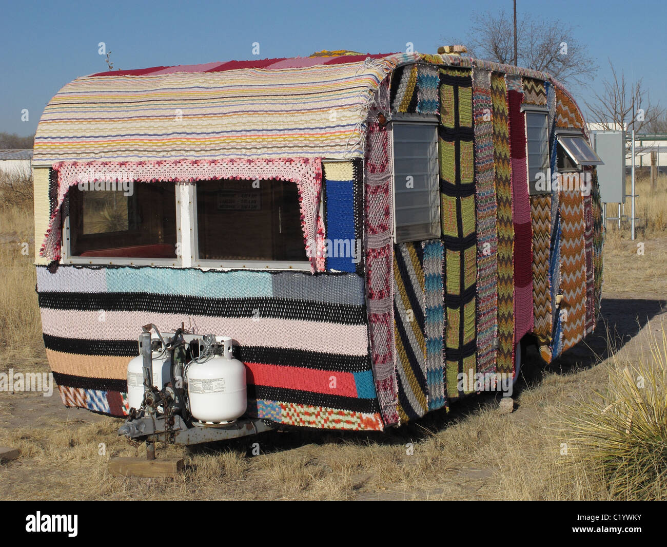 Vintage Camper trailer cubierto en tejidos de Magda Sayeg de Knitta Please. El remolque está en Marfa, Texas en El cosmico. Foto de stock