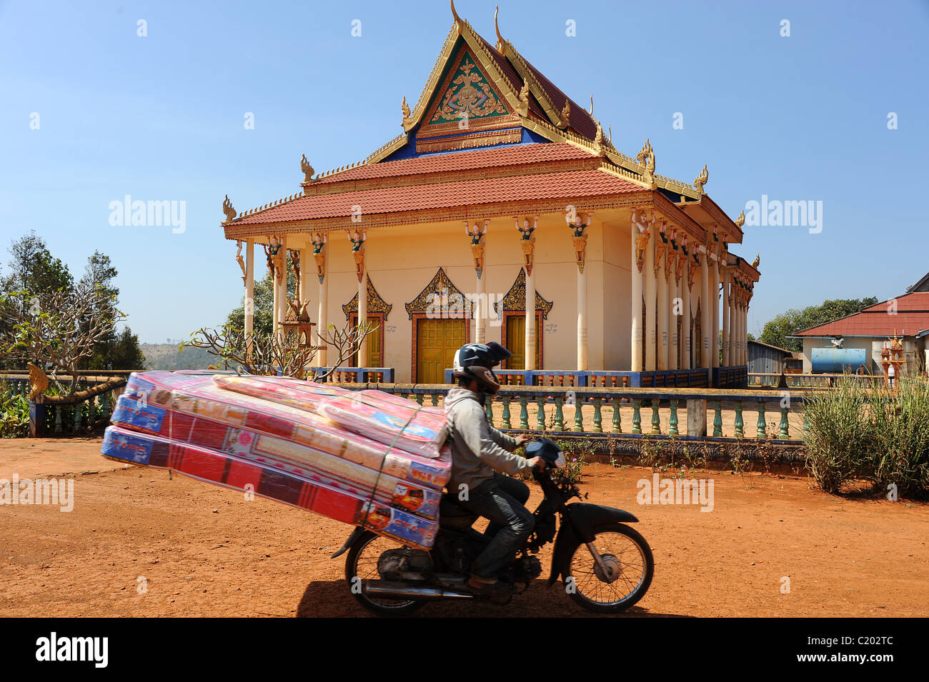 Hombre en una motocicleta con 3 grandes colchones adjunta viajando a través  del templo Fotografía de stock - Alamy