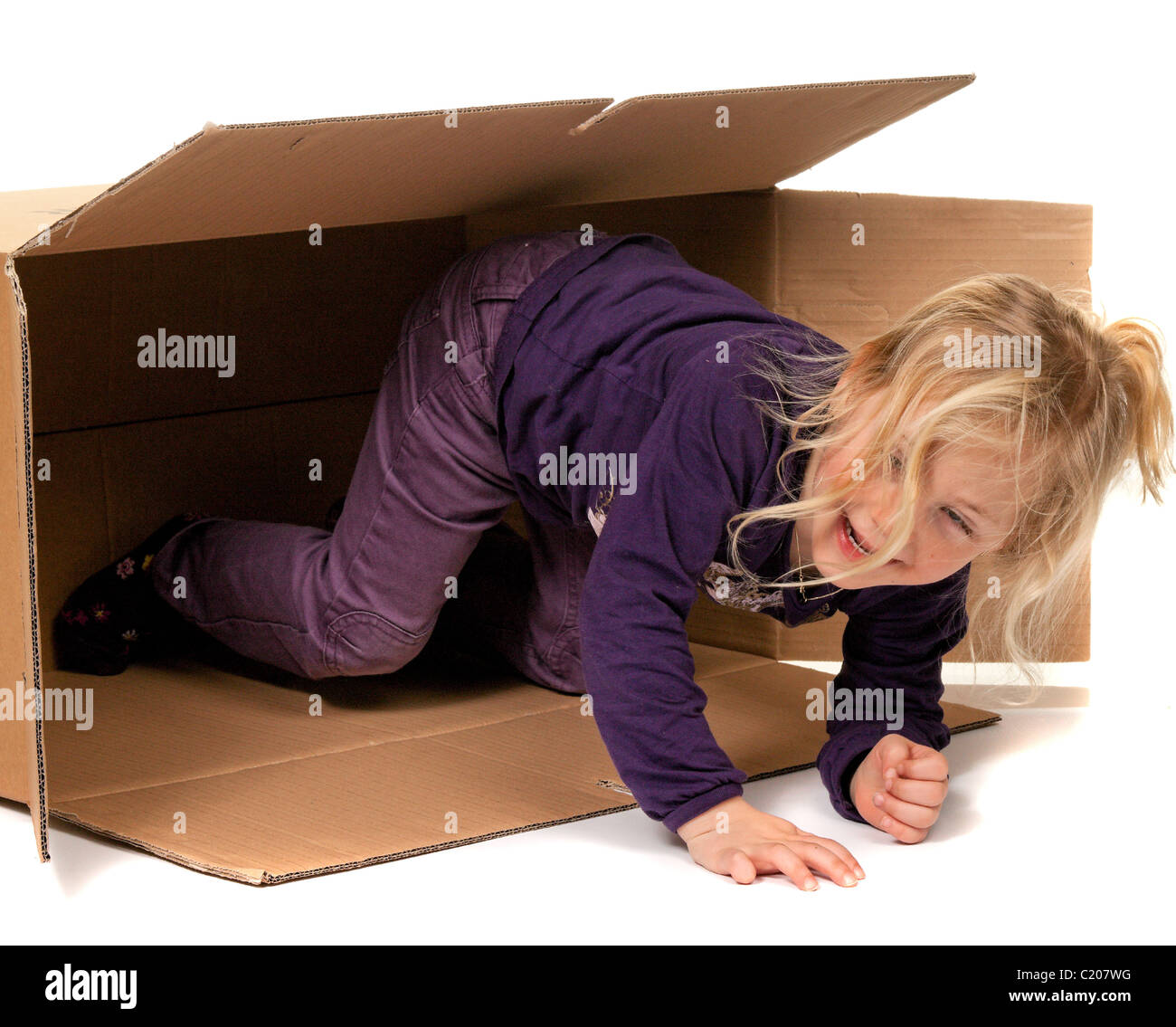 Niño en caja de cartón. Se está moviendo a la caja. Foto de stock