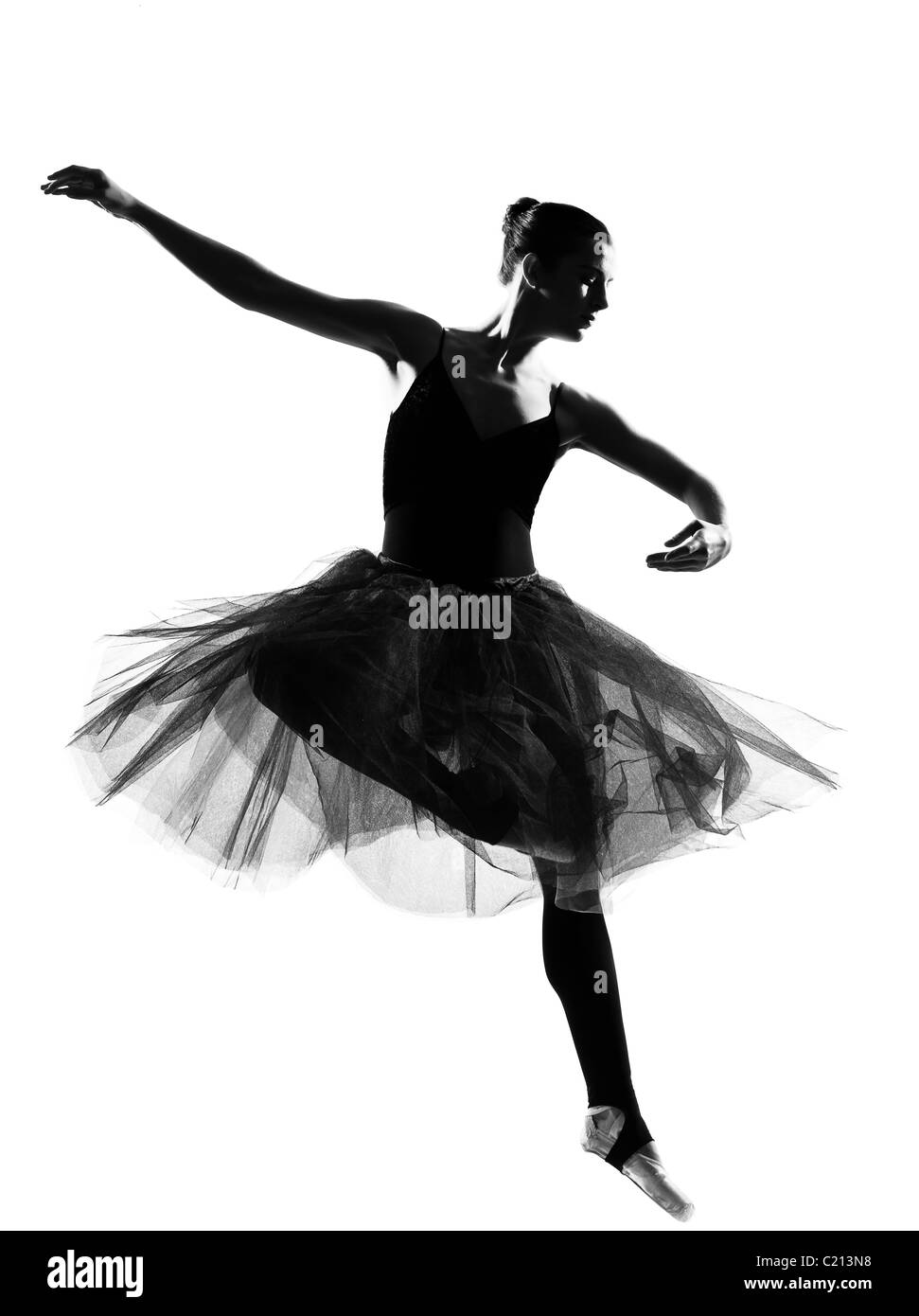 Una hermosa mujer caucásica bailarina de ballet danza salto salto de longitud completa en el studio aislado fondo blanco. Foto de stock