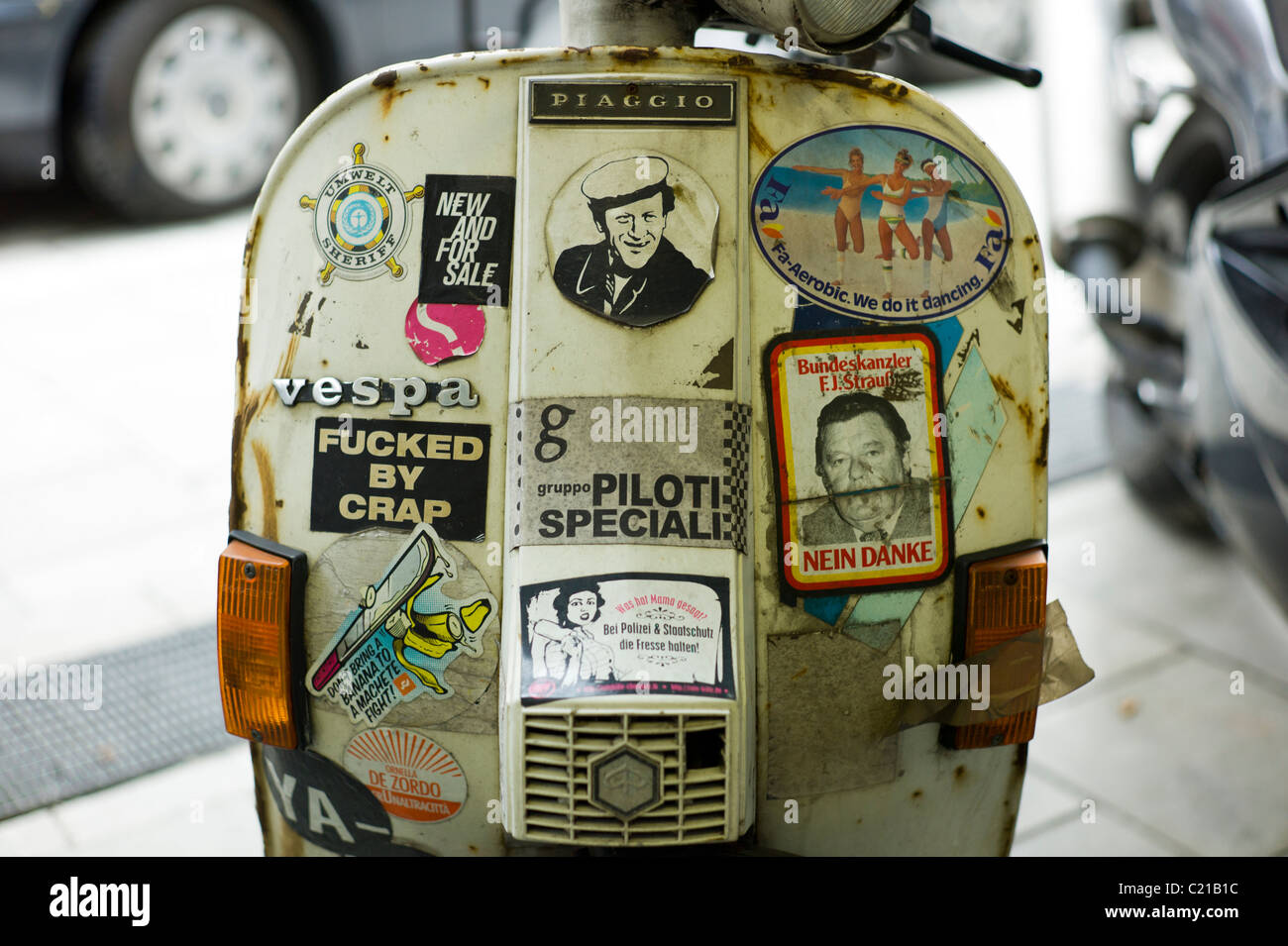 Lado frontal/escudo del viento de una moto italiana cubierto con numerosas pegatinas en el Glockenbachviertel en Munich, Alemania. Foto de stock