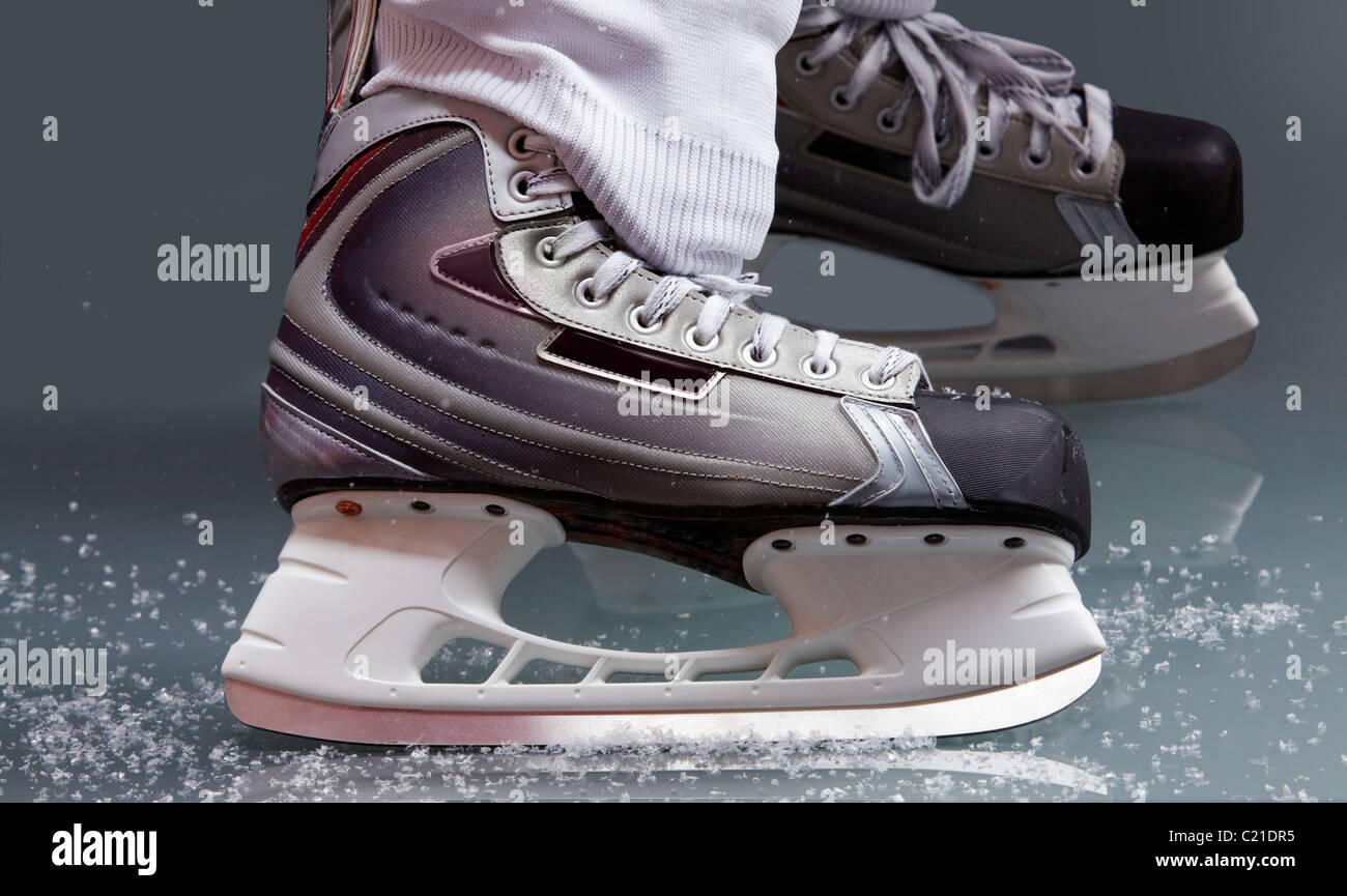 Close-up de patines en los pies de jugador durante el hockey sobre hielo Foto de stock