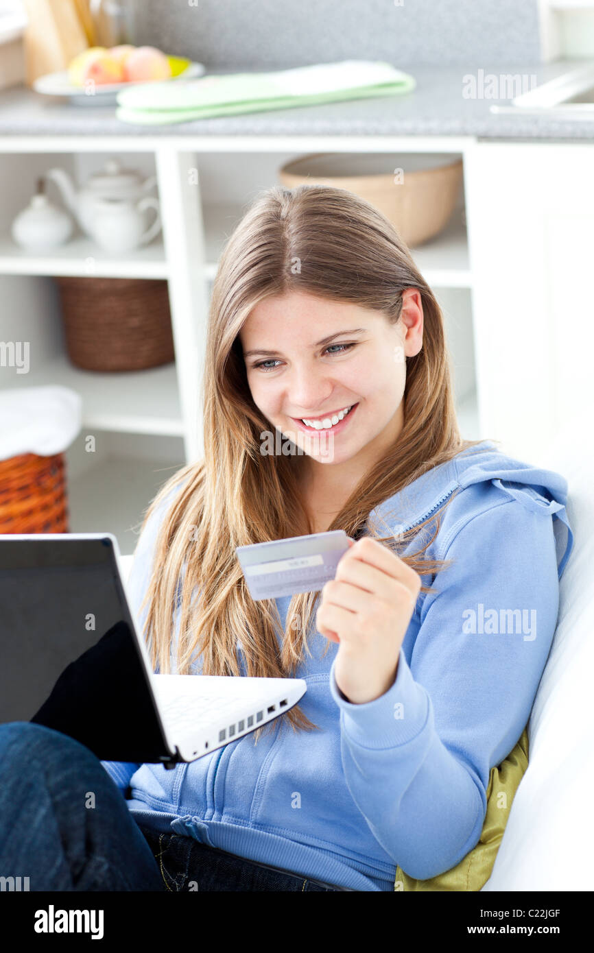 Feliz mujer con una tarjeta de crédito y un ordenador portátil Foto de stock