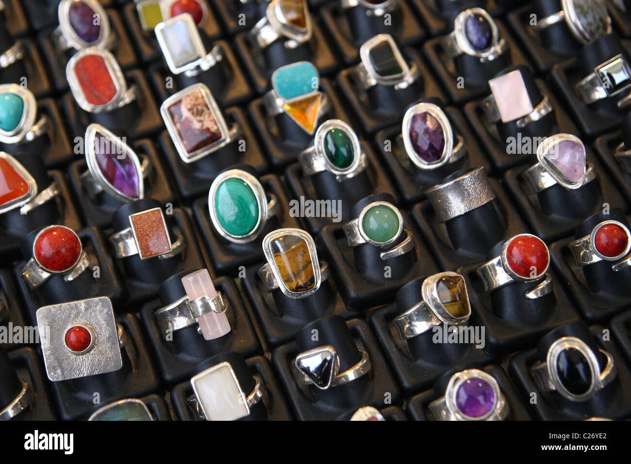 Una colección de anillos semi-preciosas en un puesto en el mercado. Foto de stock