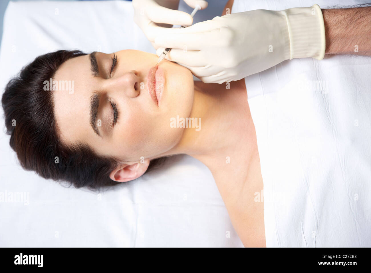 La mujer que recibe la inyección de Botox en los labios Foto de stock